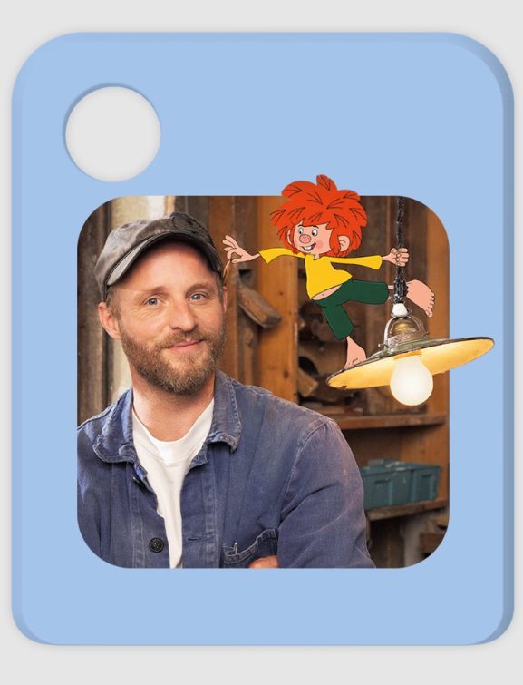Ein Mann mit Bart und Kappe neben einer Zeichentrickfigur, die an einer Lampe hängt.