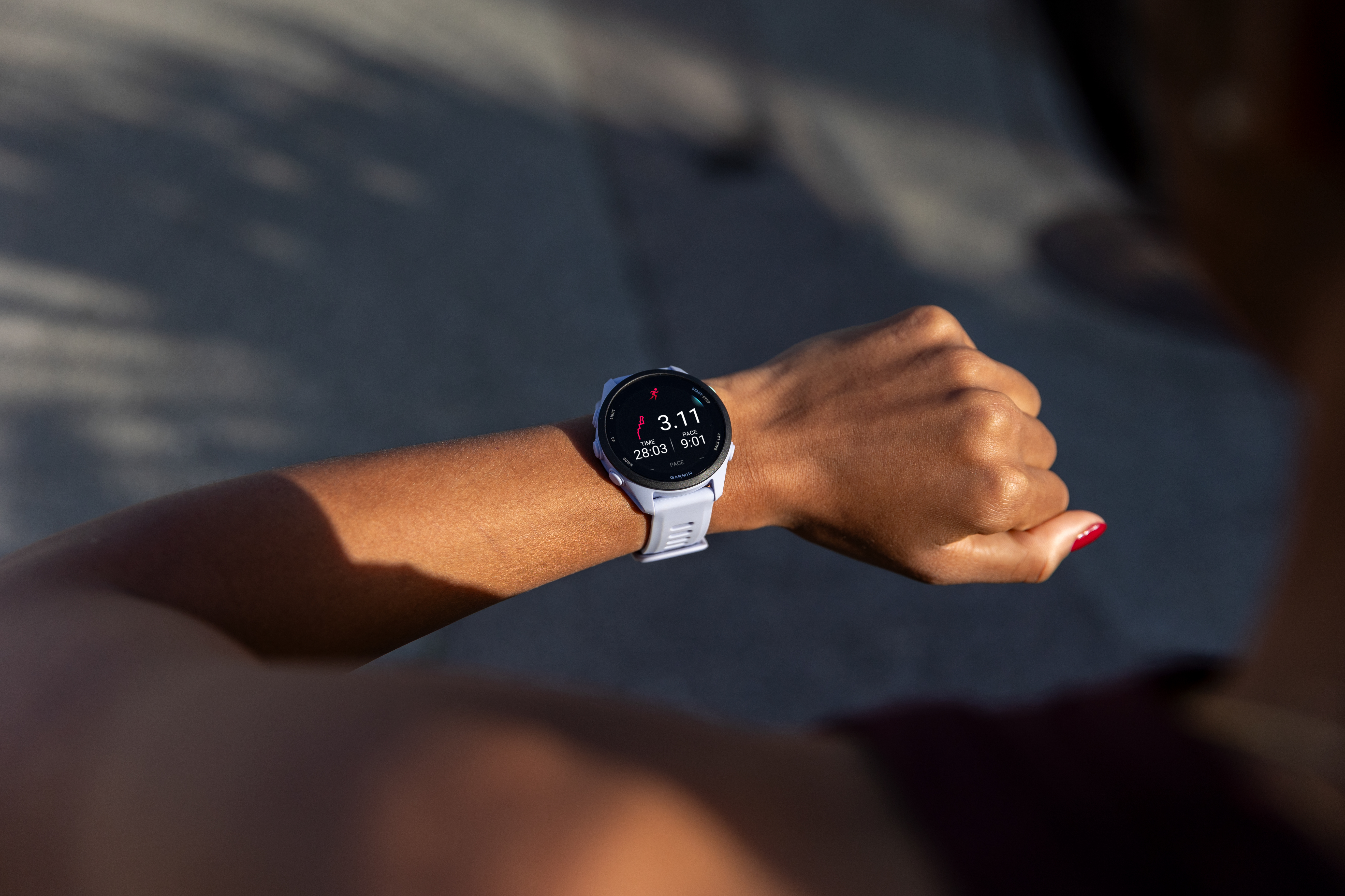 Nahaufnahme einer Hand mit einer hellblauen Smartwatch, die eine Laufstatistik anzeigt.