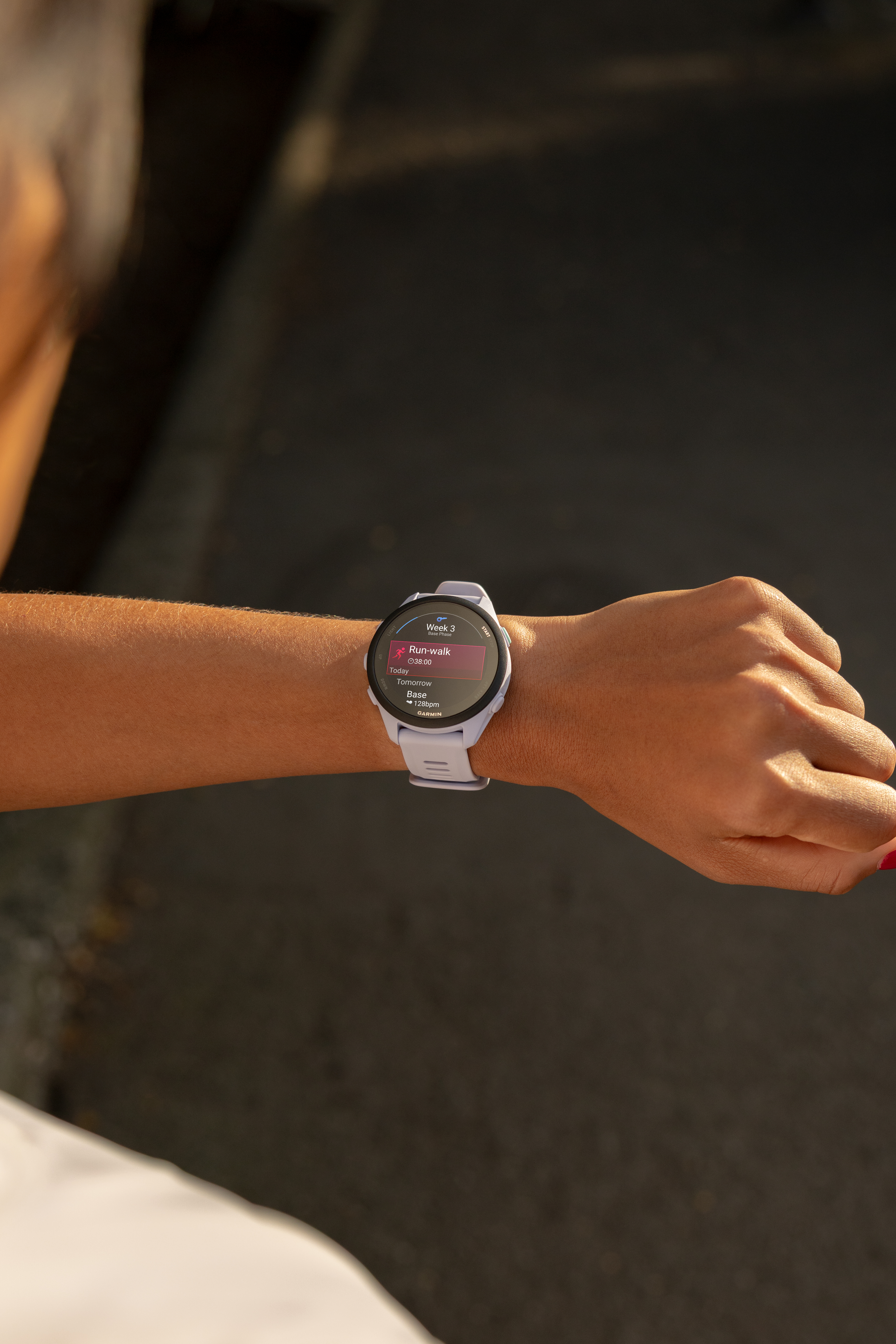 Eine Person trägt eine lila Smartwatch, die eine Lauftrainingsübersicht anzeigt.