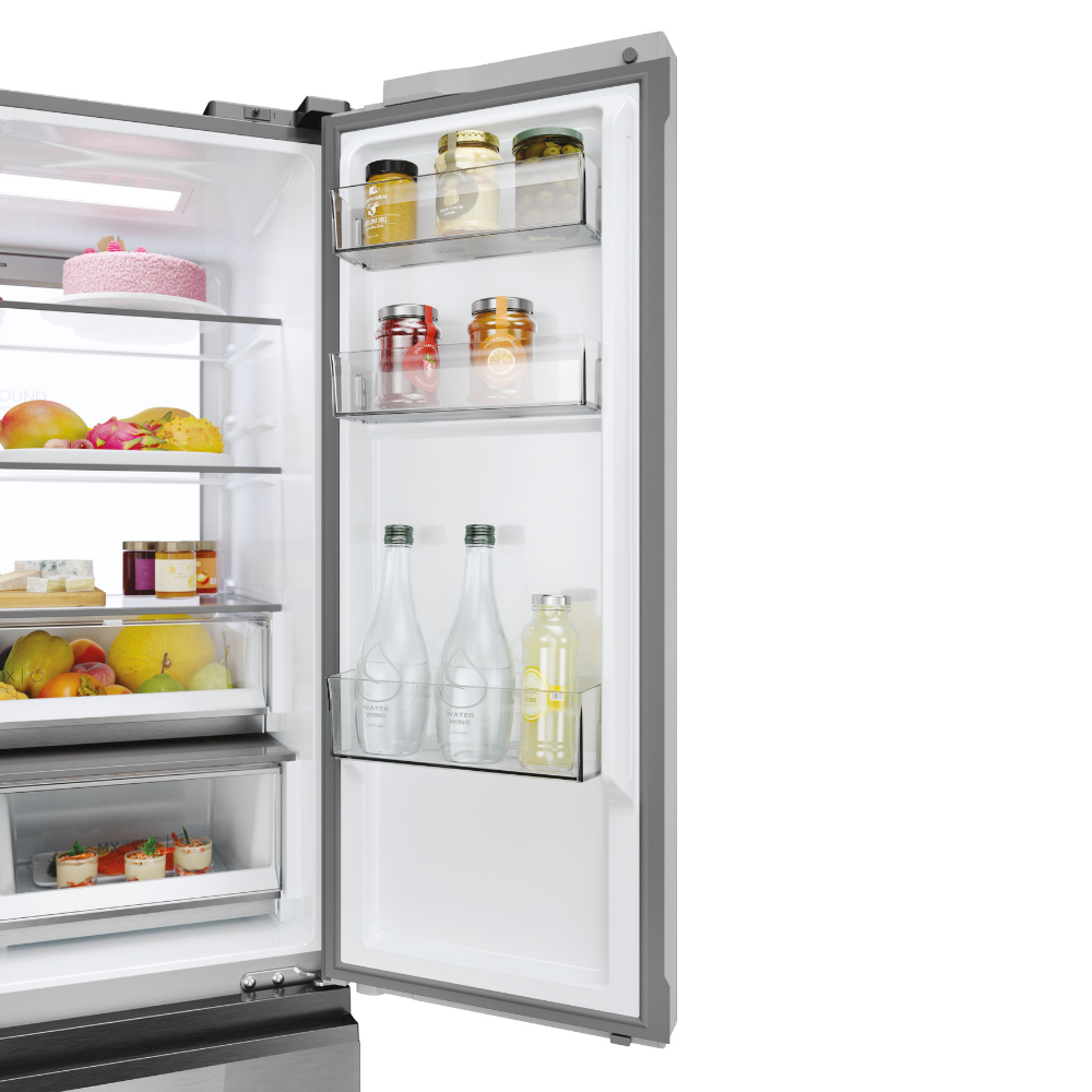 Refrigerador abierto con alimentos: pastel, fruta, frascos, botellas y queso.