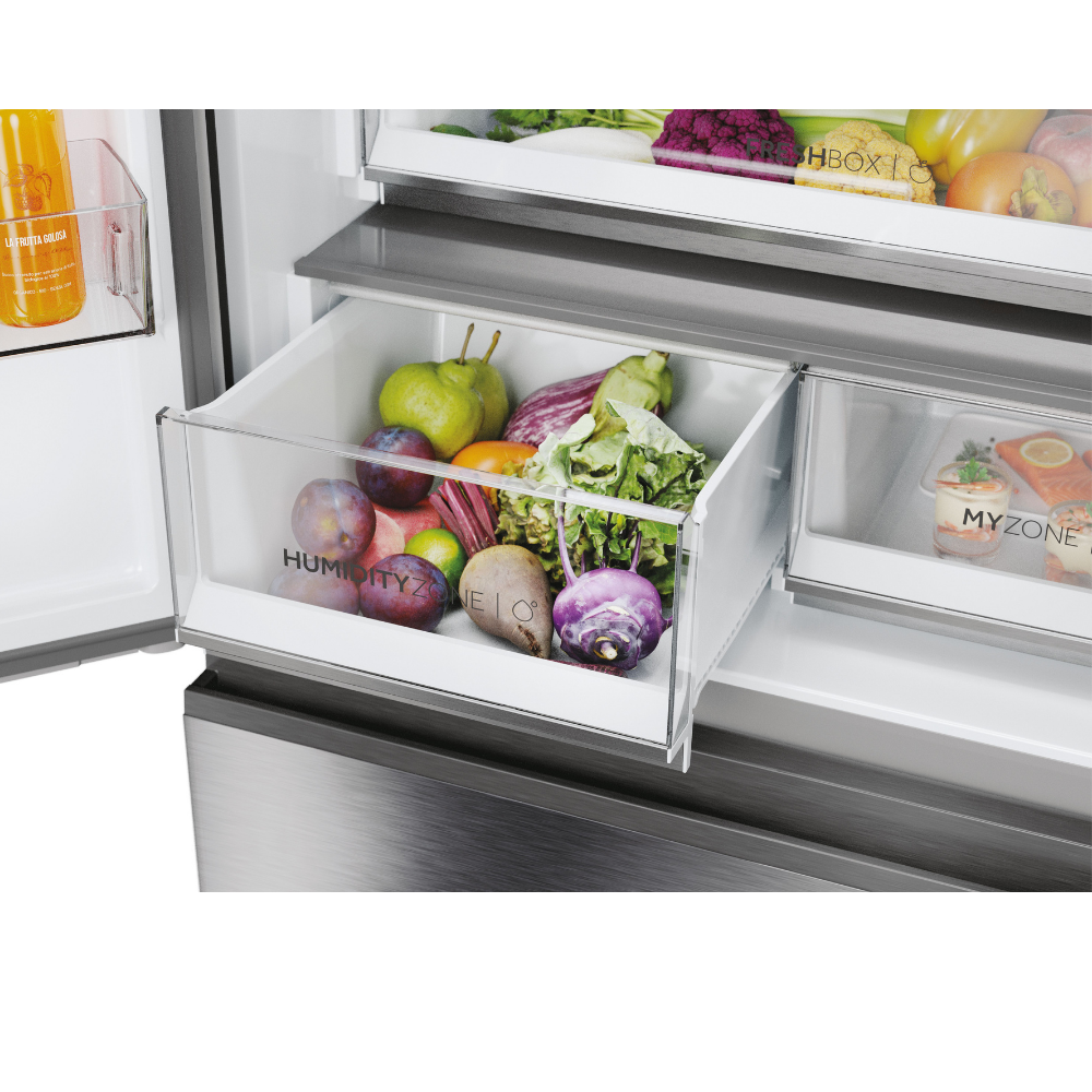 Alimentos frescos en cajones de refrigerador, incluyendo frutas, verduras y una bebida.