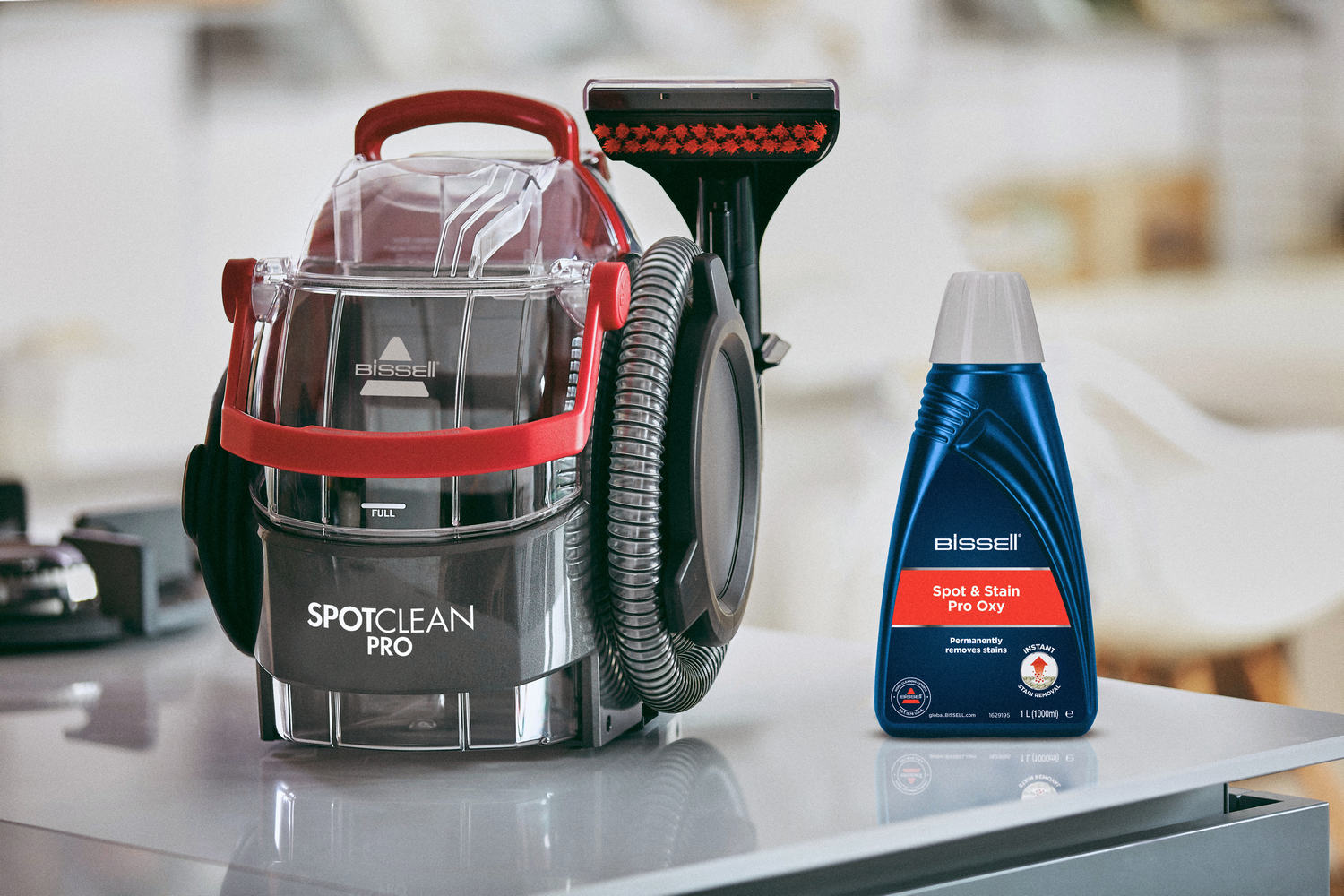 Un Bissel SpotClean Pro y una botella de Bissel Spot & Stain Pro Oxy sobre una mesa.
