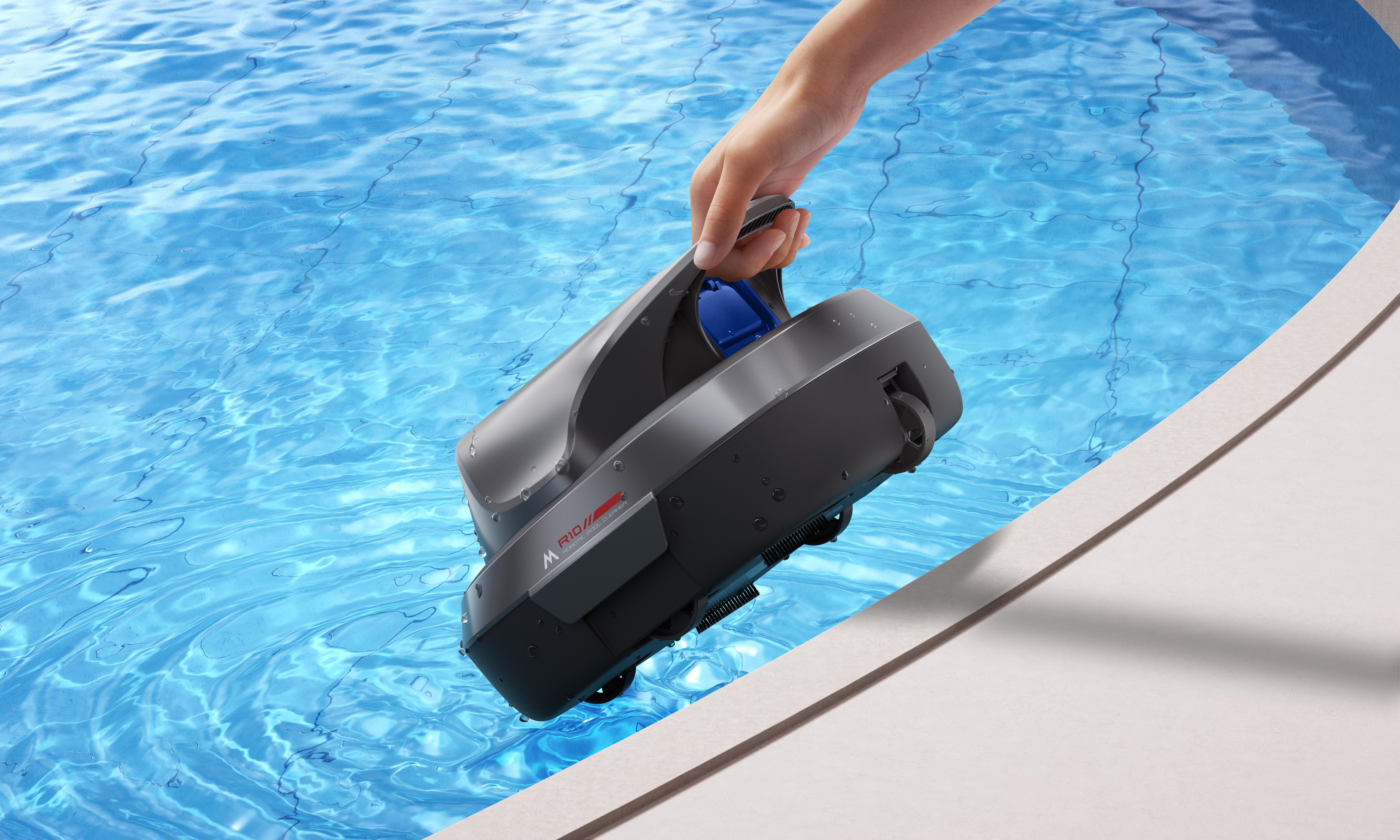 Eine Hand hält einen grauen Poolroboter, der ins blaue Wasser getaucht wird.