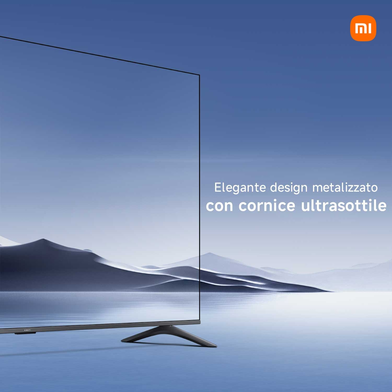Un TV elegante con cornice metallizzata davanti a un paesaggio di montagne e lago.