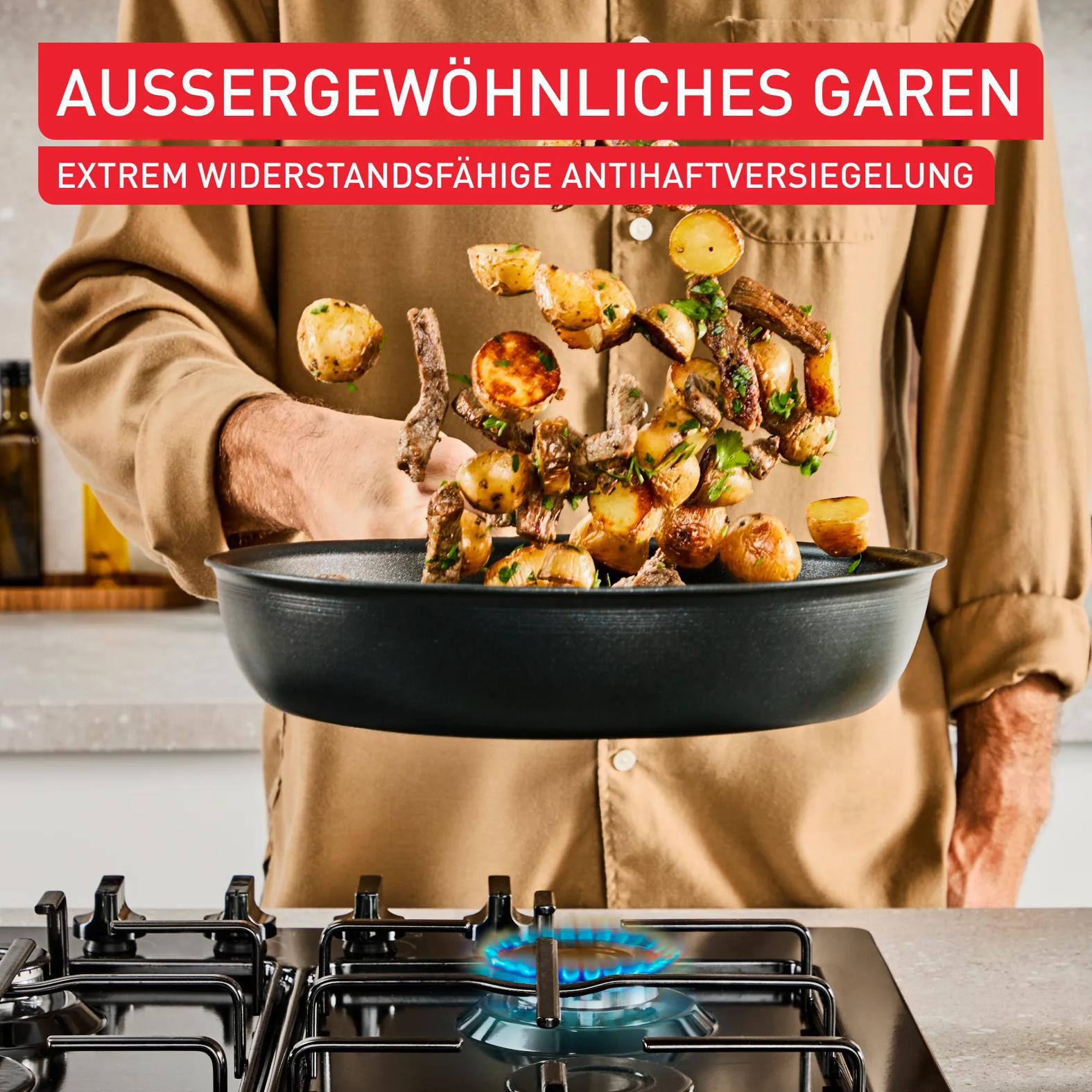 Ein Mann wirft Bratkartoffeln und Fleisch über einer Pfanne in die Luft.