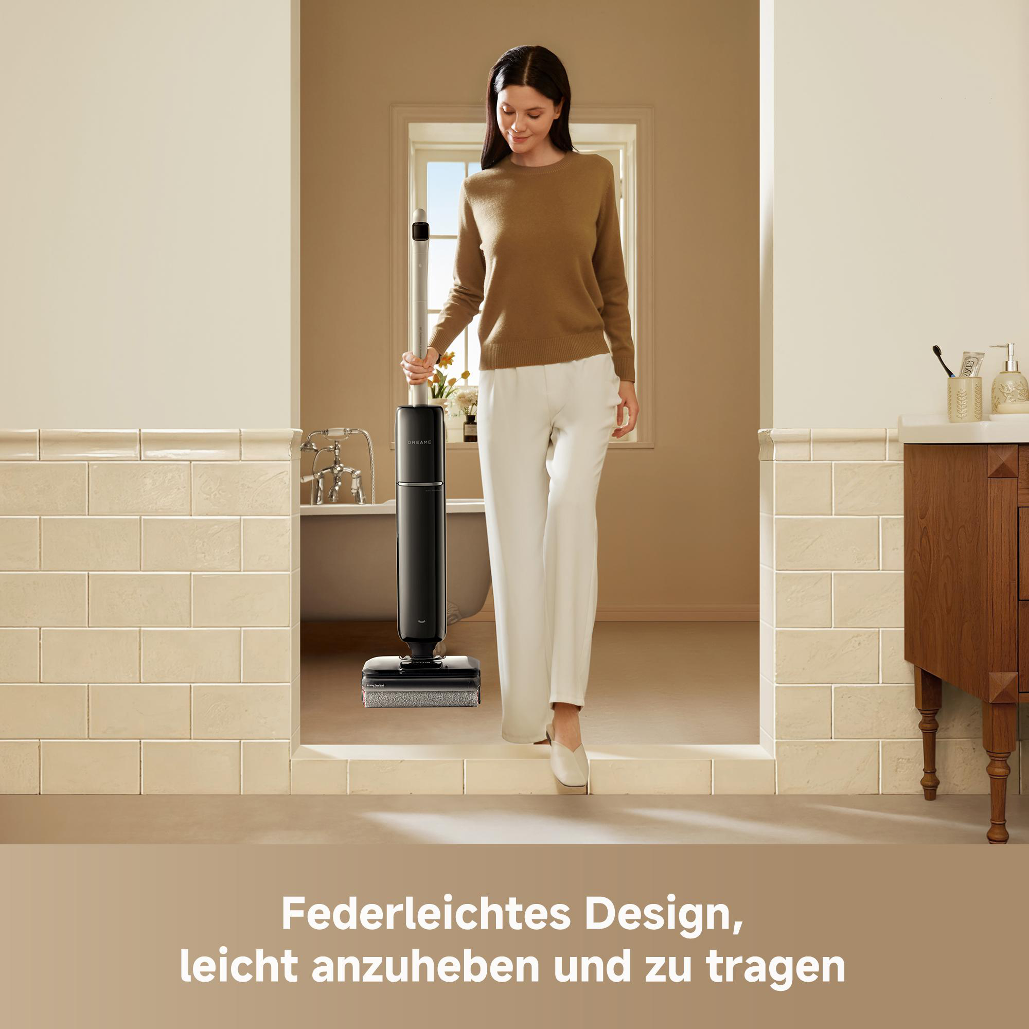 Frau im Bad mit einem schwarzen Bodenreiniger, weiße Hose, brauner Pullover.