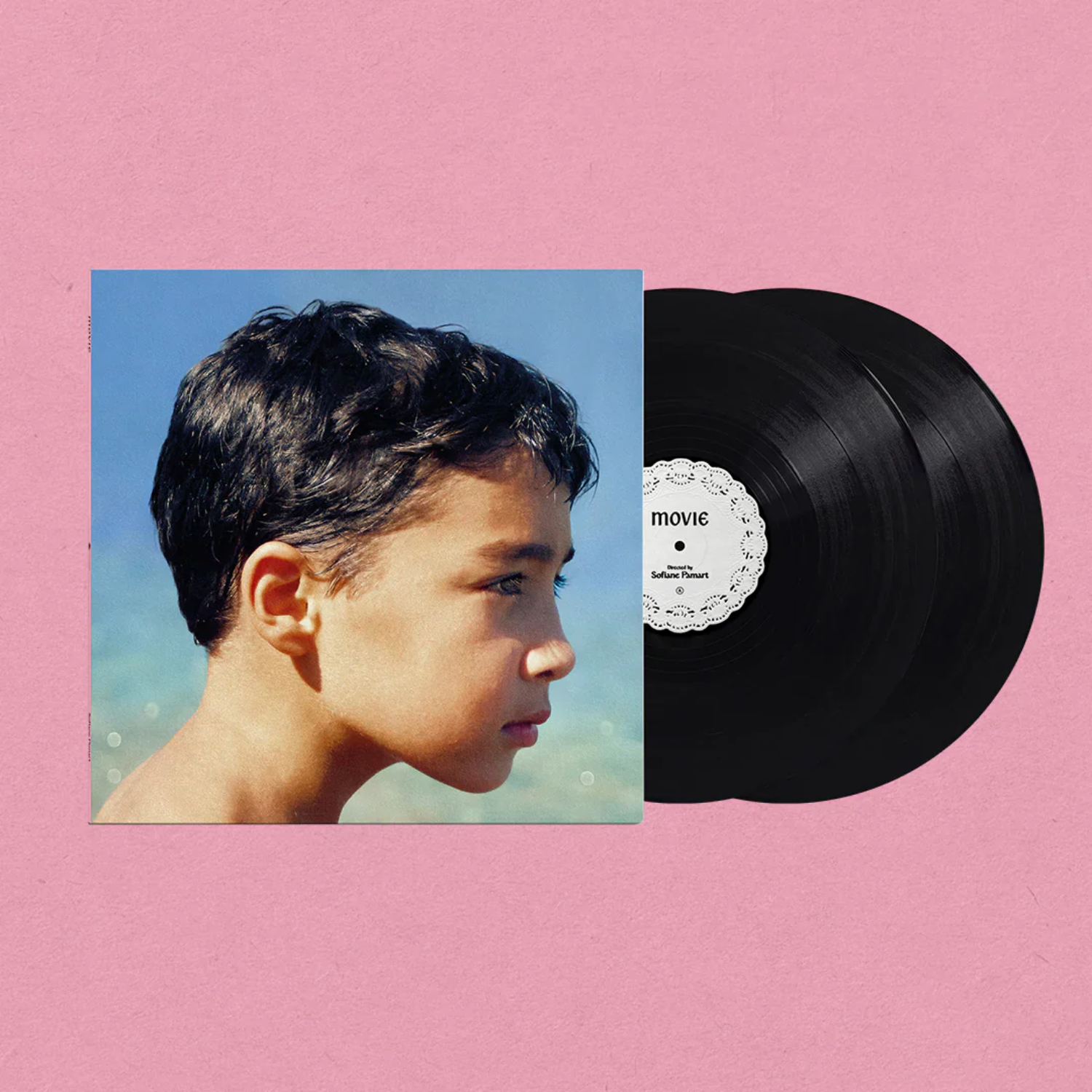Pochette d'album avec profil de garçon et deux vinyles sur fond rose.