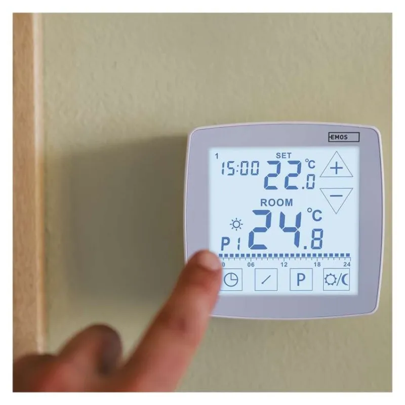Egy ujj érint meg egy digitális termosztátot, amely 22,8°C-ot mutat.