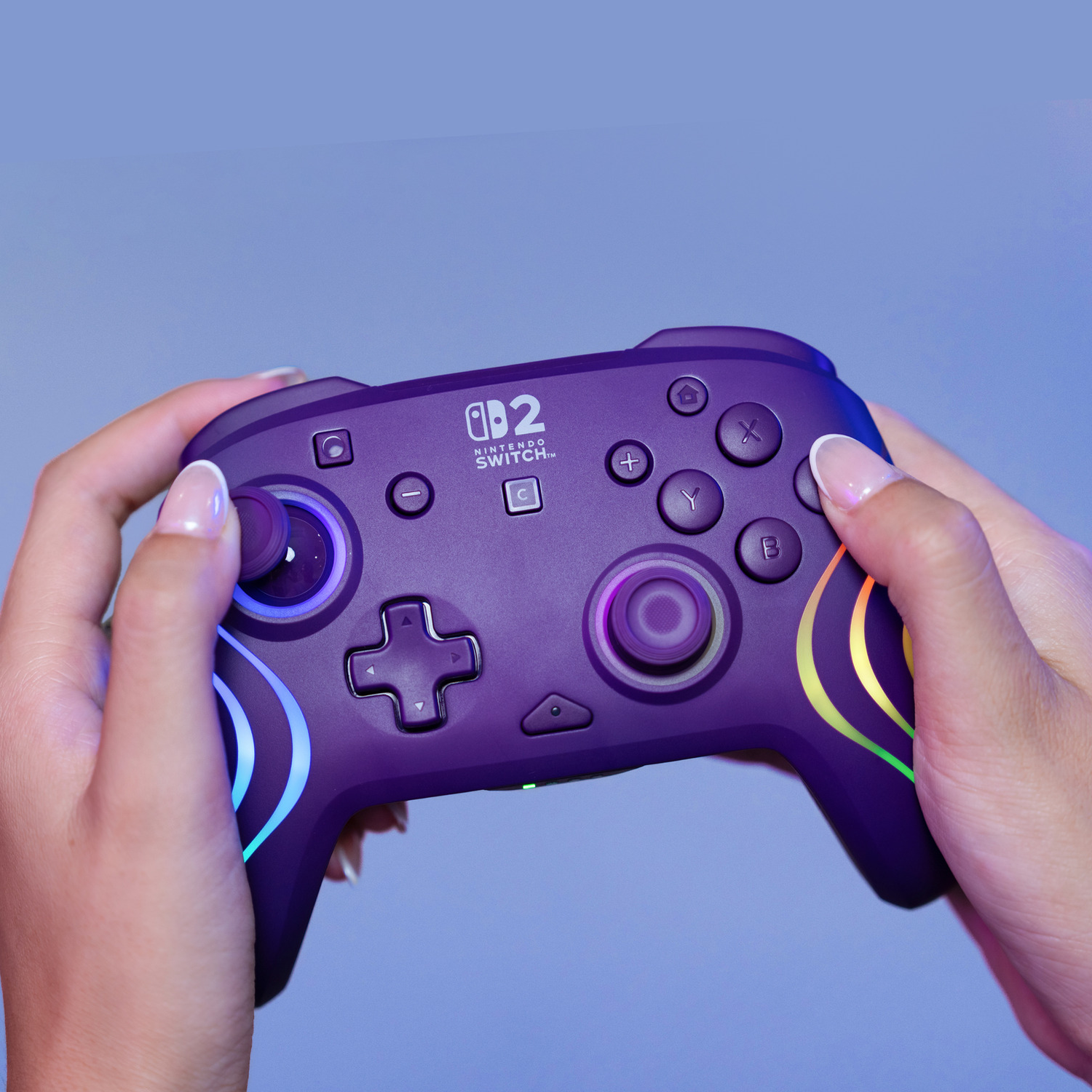 Person holds purple Nintendo Switch controller with illuminated accents.