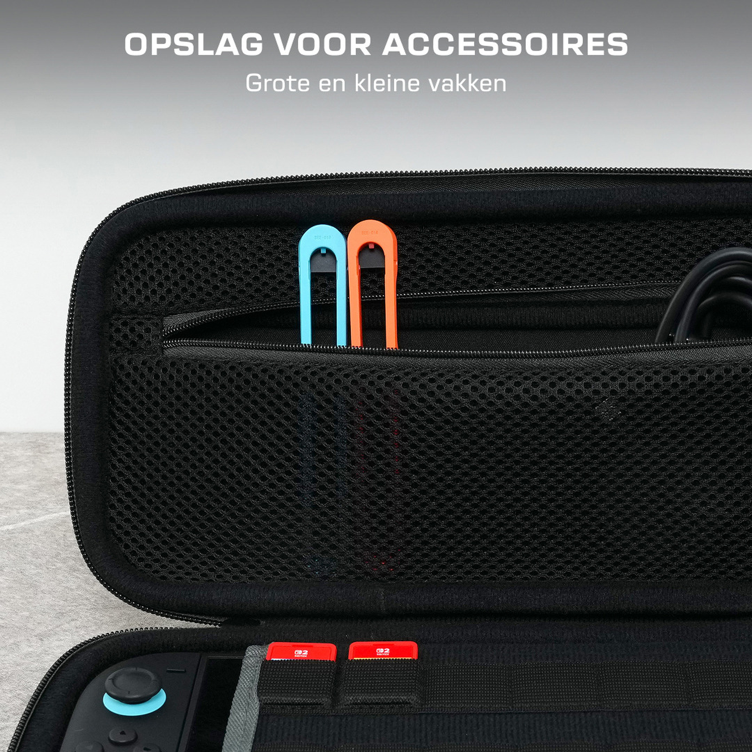 Zwarte hoes met blauwe en oranje handvatten, Nintendo Switch en spelcartridges.