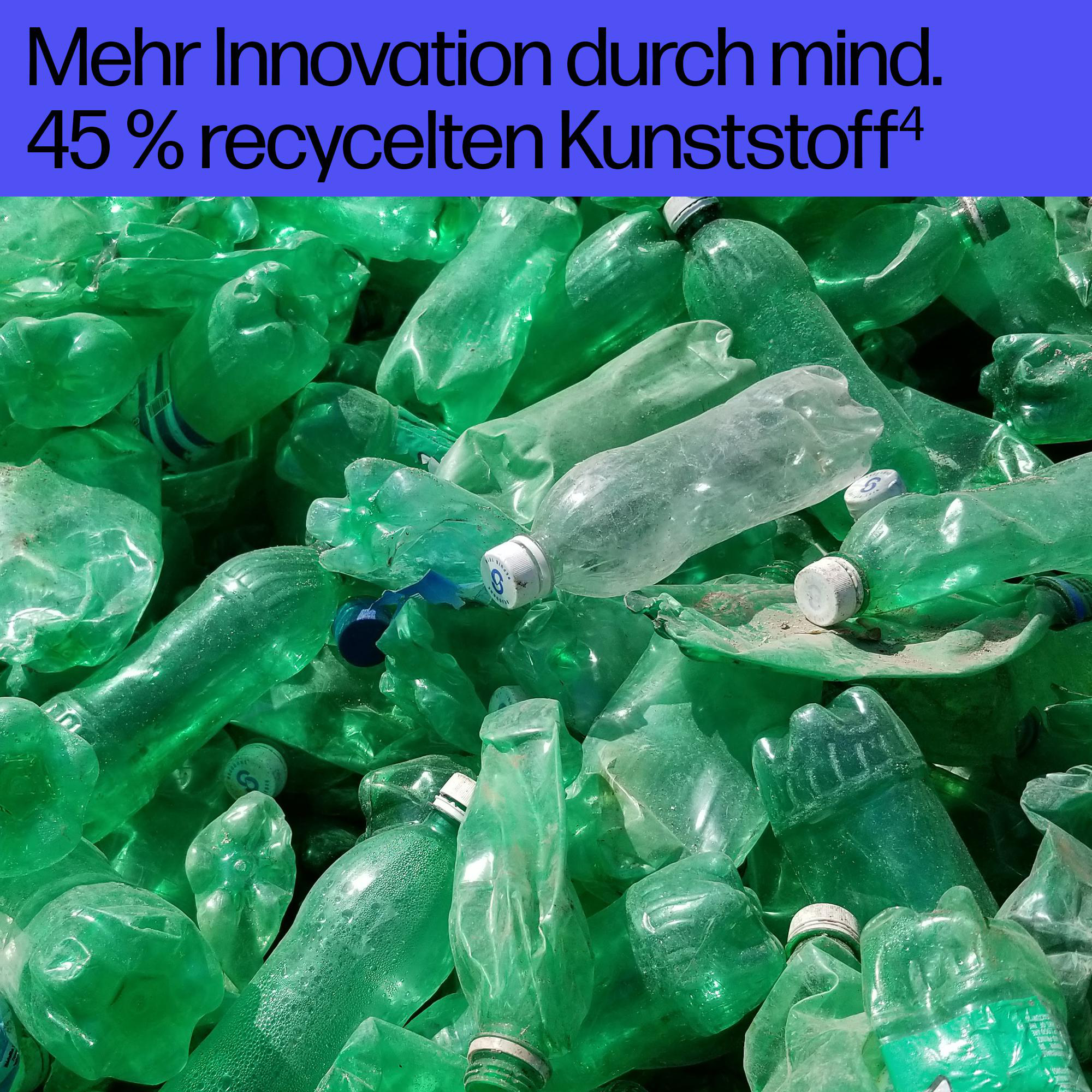 Ein Haufen zerdrückter grüner Plastikflaschen, einige mit weißen oder blauen Verschlüssen.