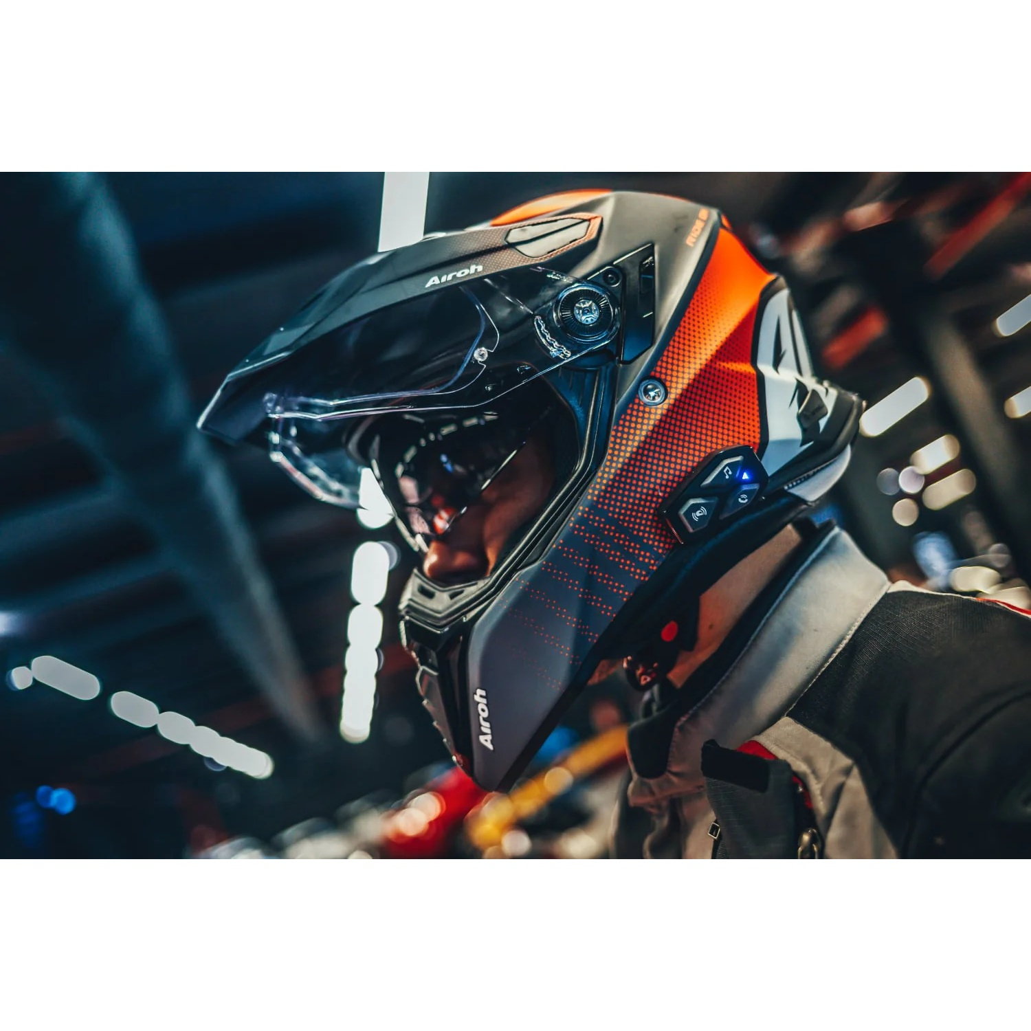 Un uomo indossa un casco da moto nero e arancione con visiera.