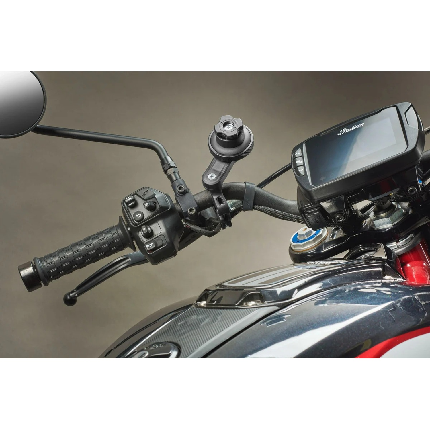 Primo piano del manubrio di una moto con display digitale, specchietto e comandi.
