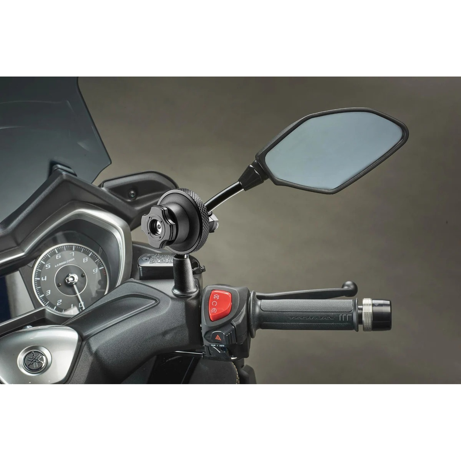 Manubrio moto con specchietto, cruscotto e manopola. Primo piano.