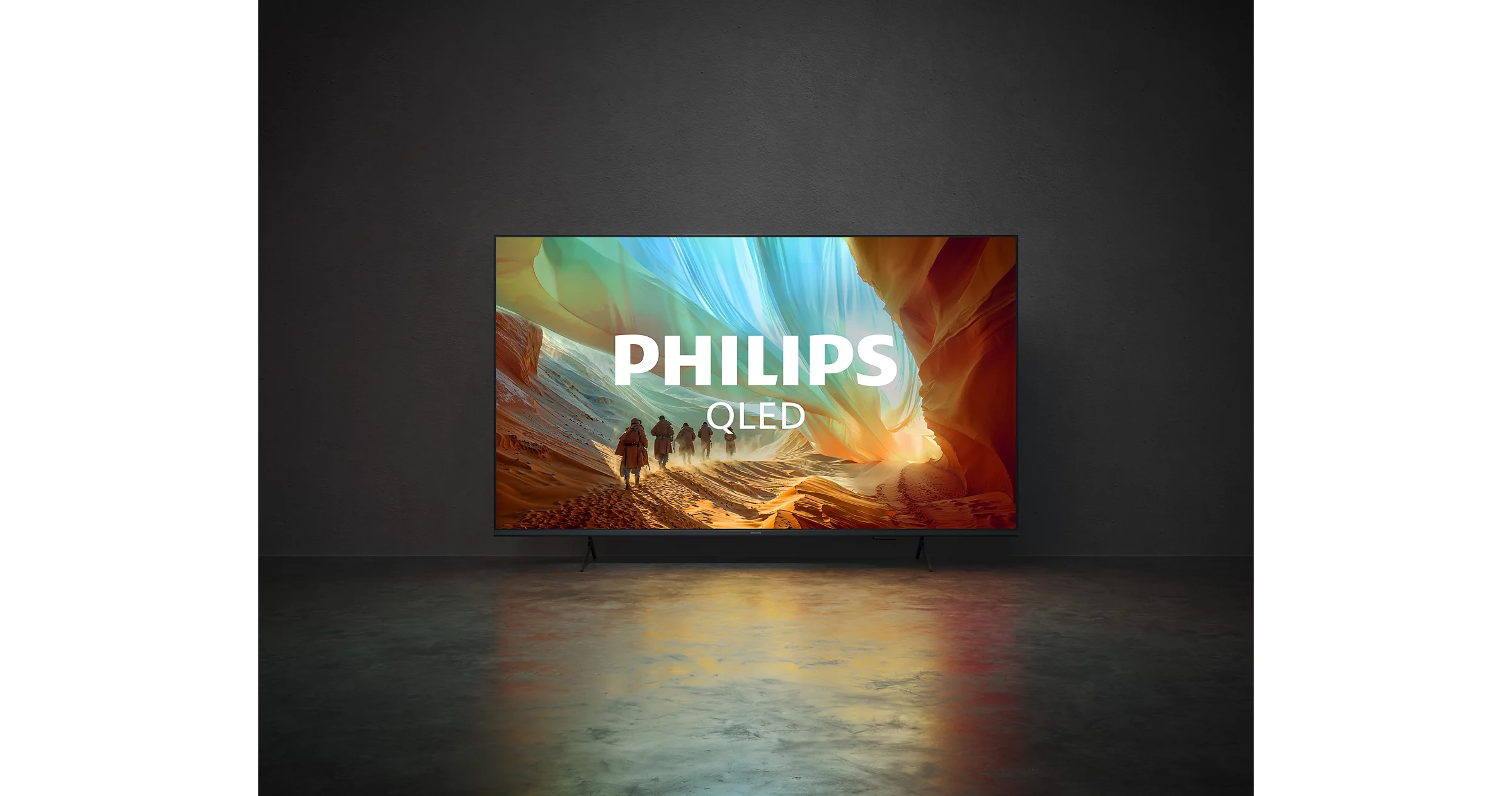 Ein Philips QLED Fernseher zeigt eine Landschaft mit Wanderern und bunten Stoffbahnen.