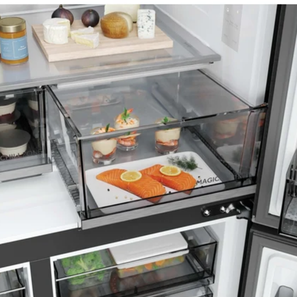 Cajón de refrigerador abierto con filetes de salmón y aperitivos. Queso en el estante superior.