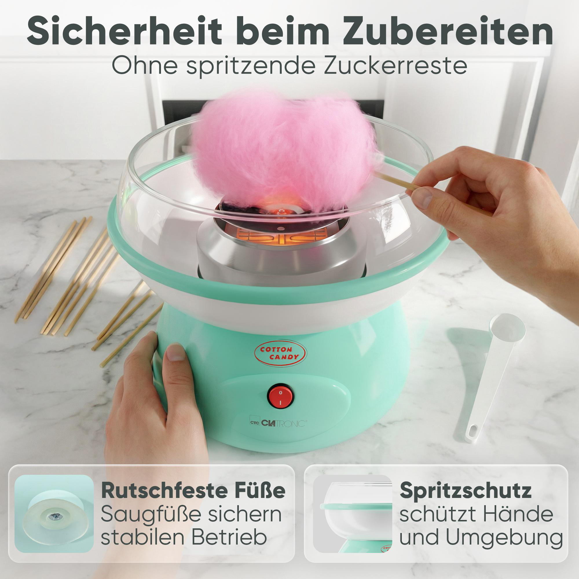 Ein rosa Zuckerwatte-Automat mit Holzstäbchen und einer Hand, die eine Zuckerwatte formt.