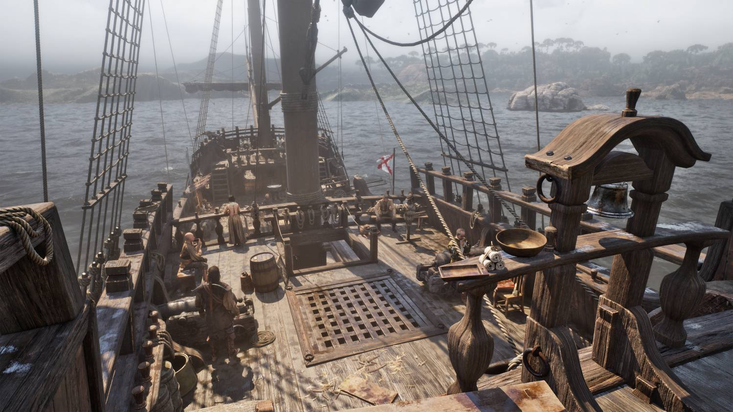 Vista de la cubierta de un viejo barco de madera con velas, tripulación y el mar al fondo.