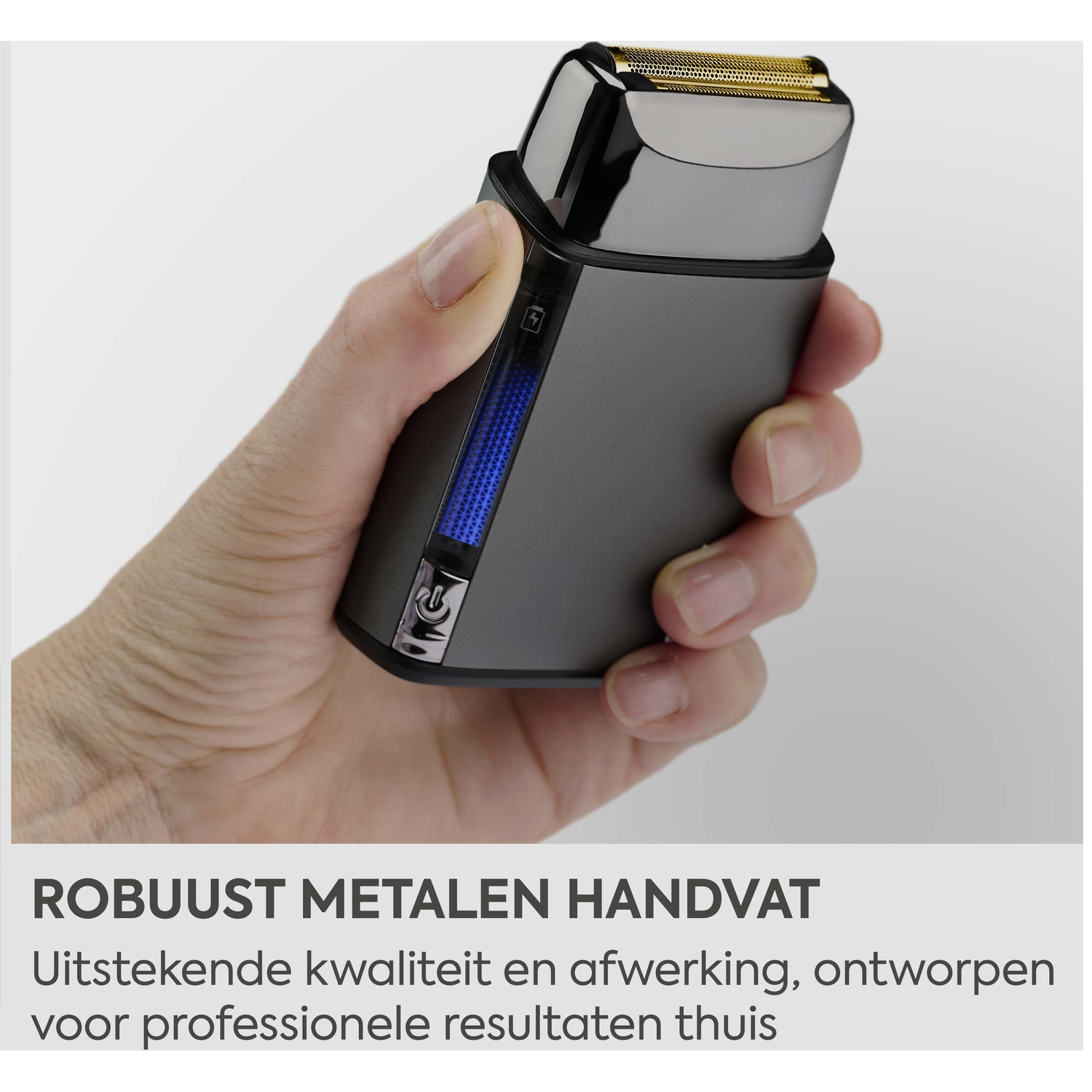 Een hand houdt een donkere scheerapparaat vast met gouden folie en blauwe indicator.