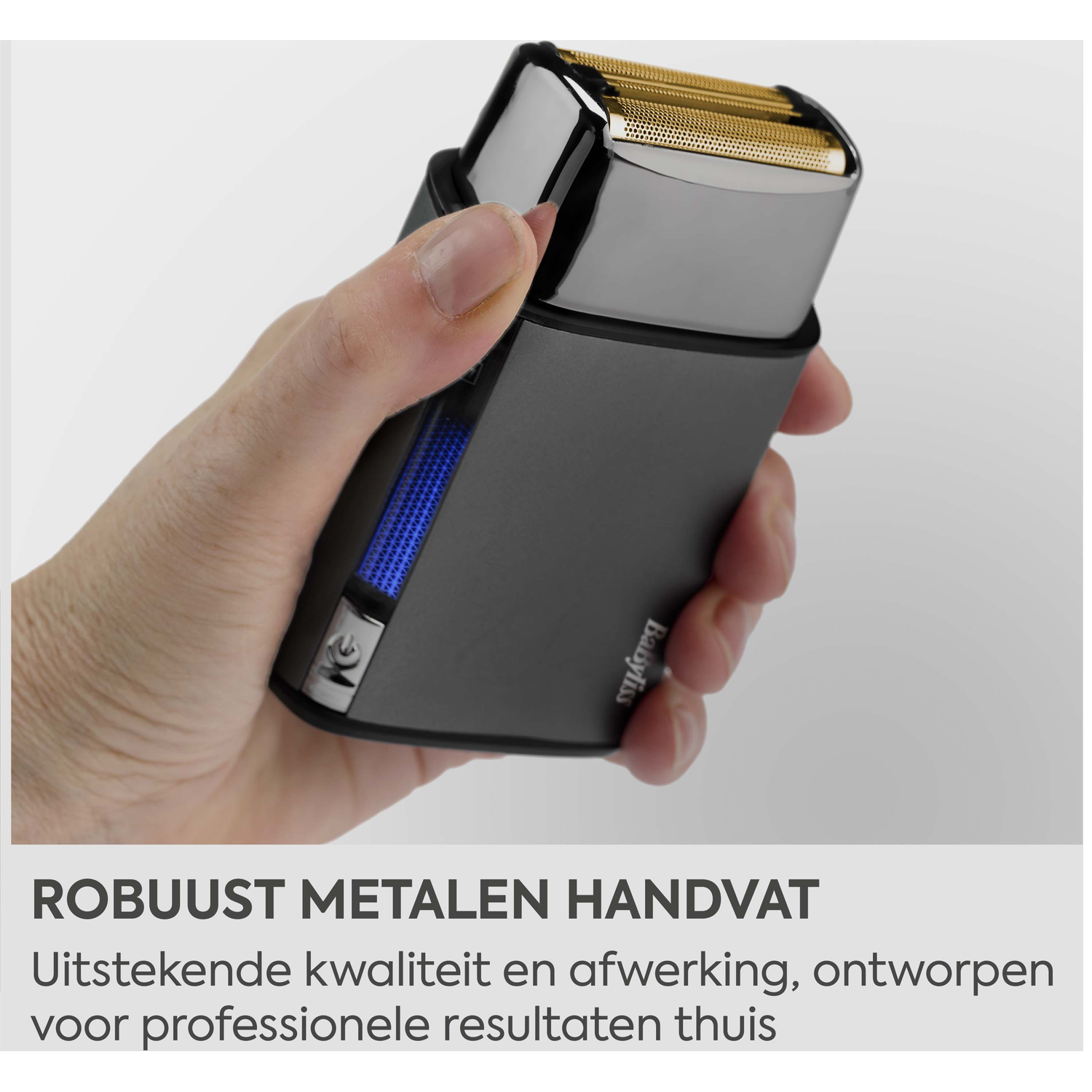 A hand holds a dark shaver with a gold foil head and blue display.