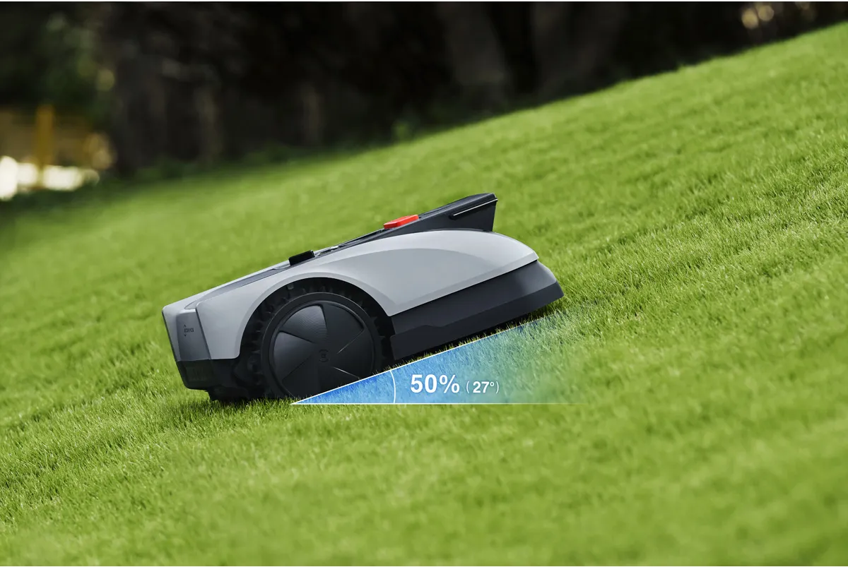 Ein Mähroboter auf einem grünen Rasen mit einem Neigungsindikator von 50% (27°).