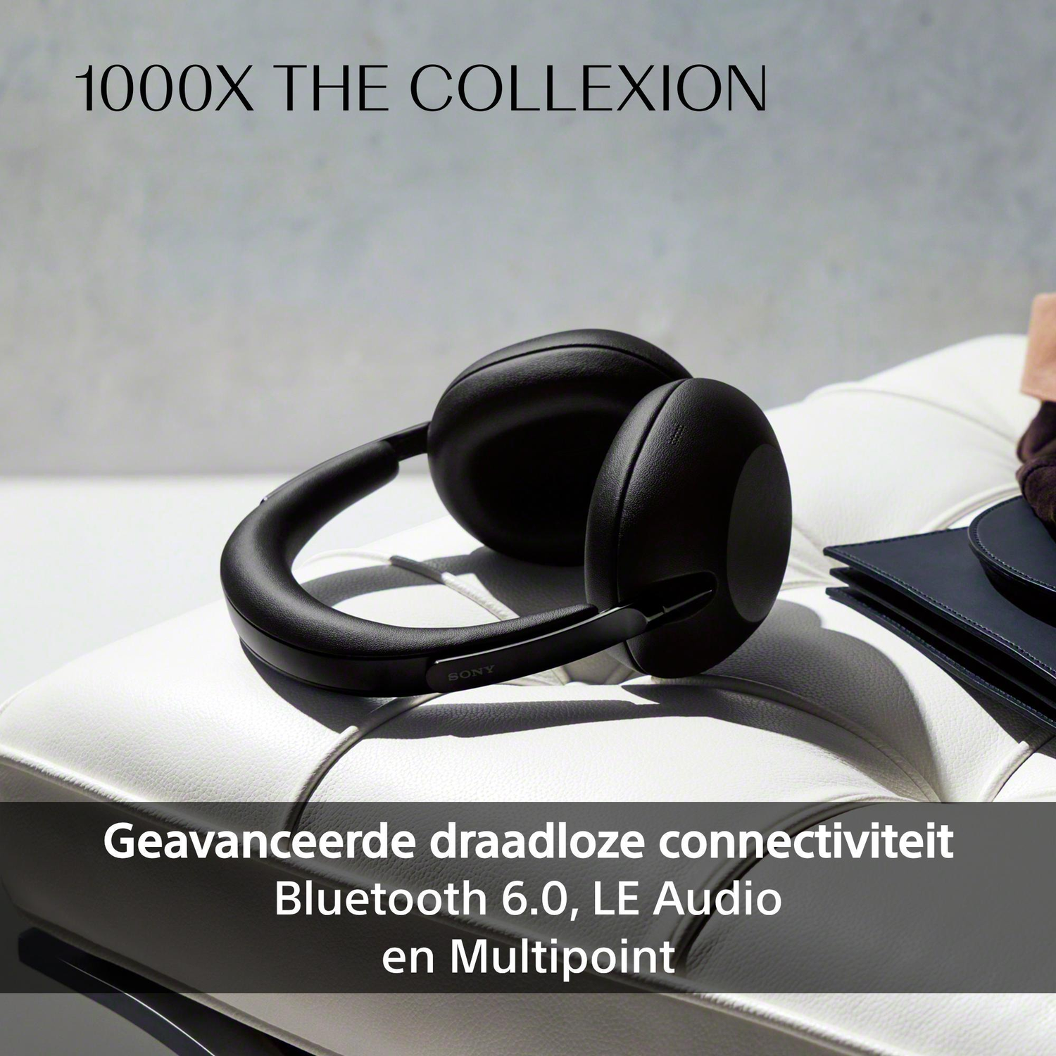 Black Sony headphones on a white leather sofa.