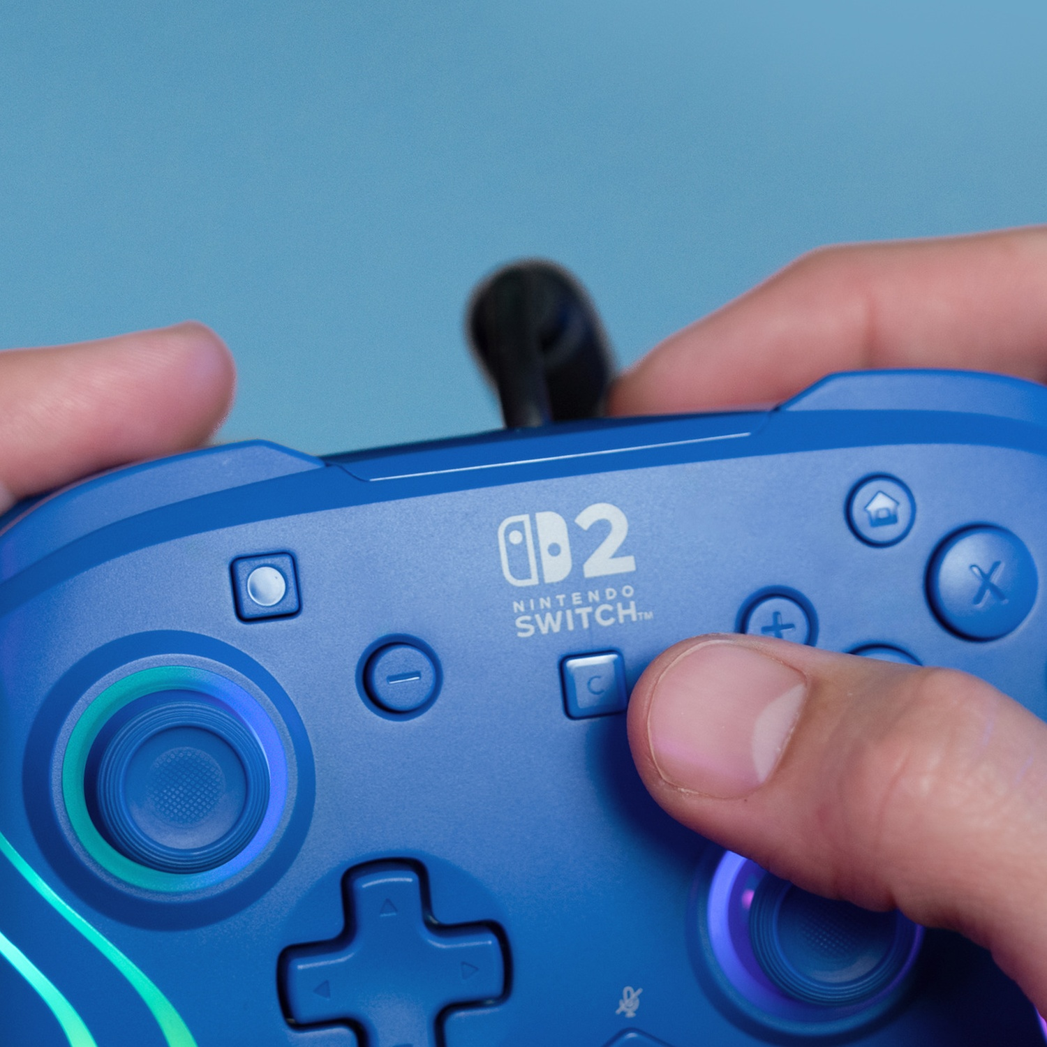 Manette bleue Nintendo Switch avec lumières, tenue par des mains.