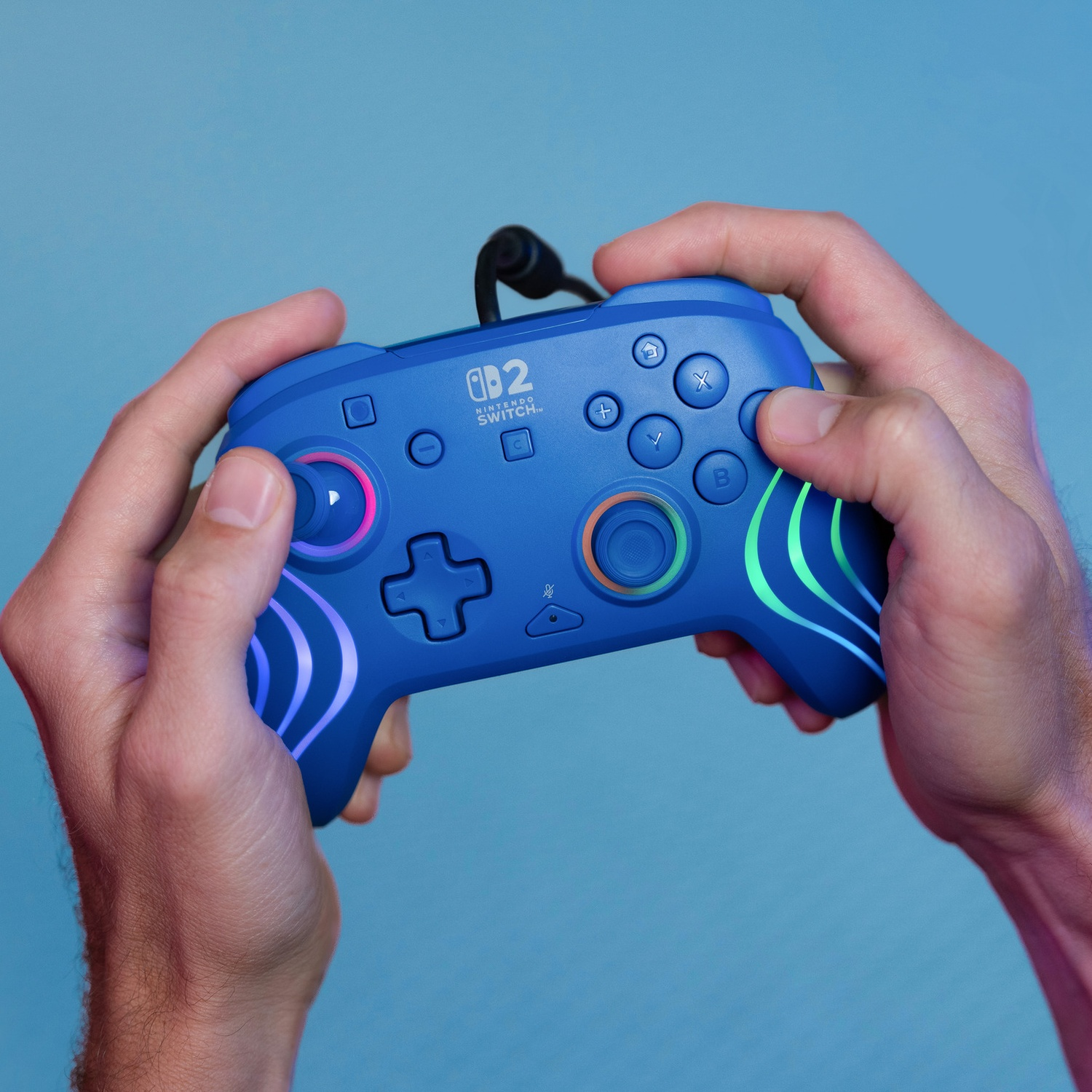 Manette bleue Nintendo Switch avec lumières, tenue par des mains.