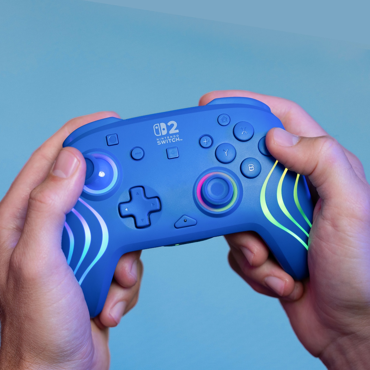 Manette bleue Nintendo Switch avec rayures lumineuses, tenue par des mains.