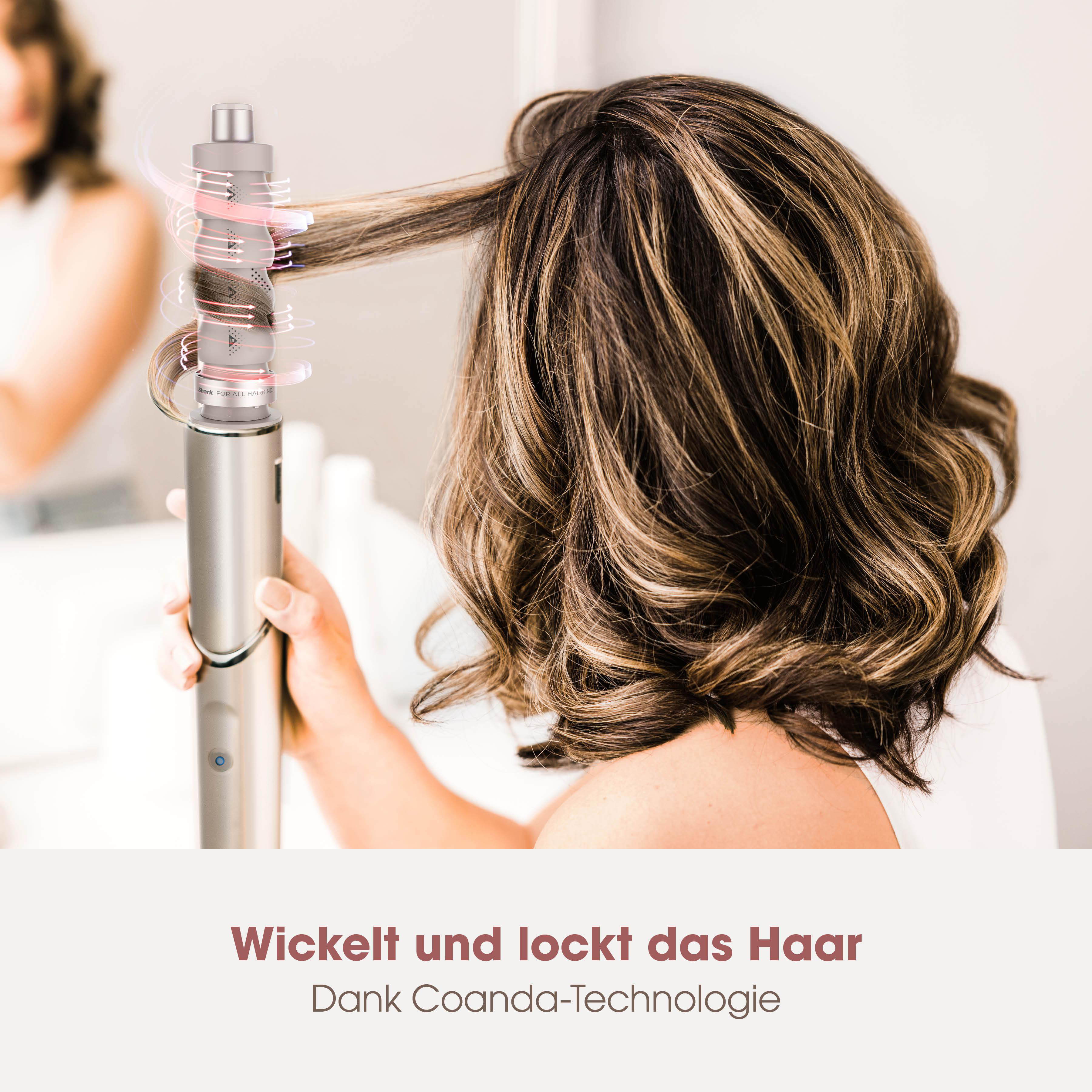 Ein silberner Lockenstab wickelt braunes Haar. Luftströme werden gezeigt.