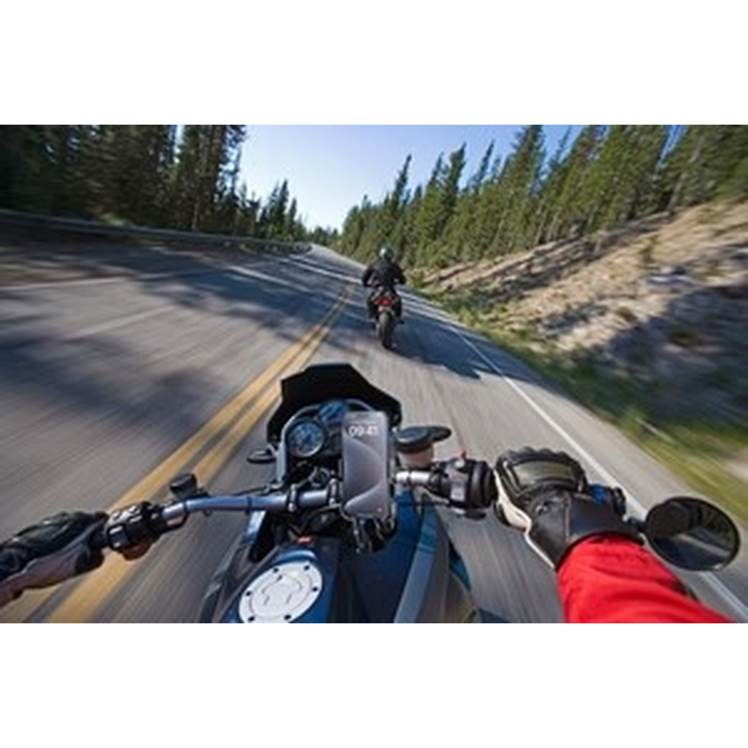 Motociclisti su una strada con alberi sullo sfondo.