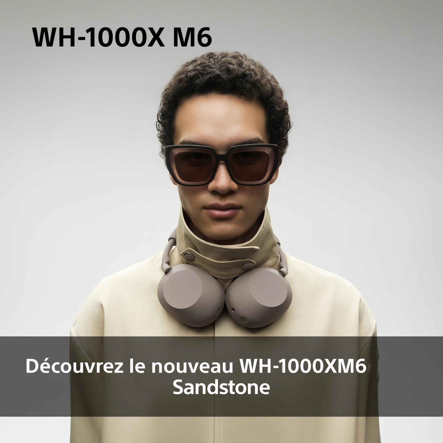 Homme avec lunettes de soleil et casque autour du cou porte une veste beige.