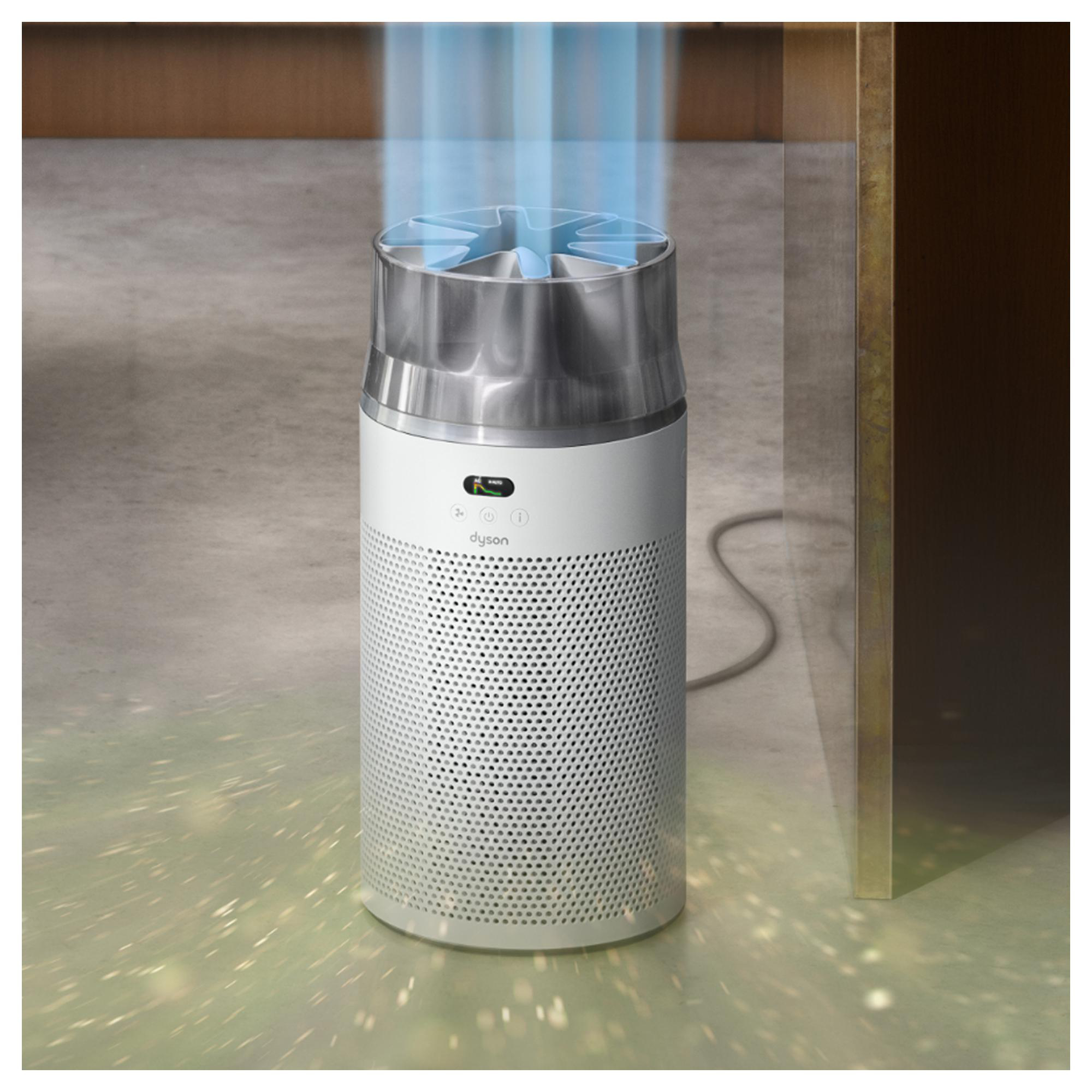 Ein weißer Luftreiniger von Dyson mit blauem Luftstrom oben auf einem Betonboden.