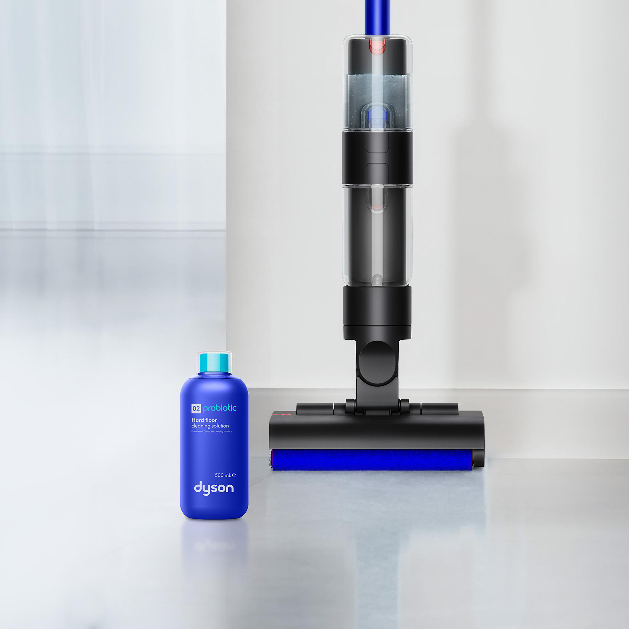 Ein blauer Dyson Flaschenreiniger steht neben einem Dyson Staubsauger.