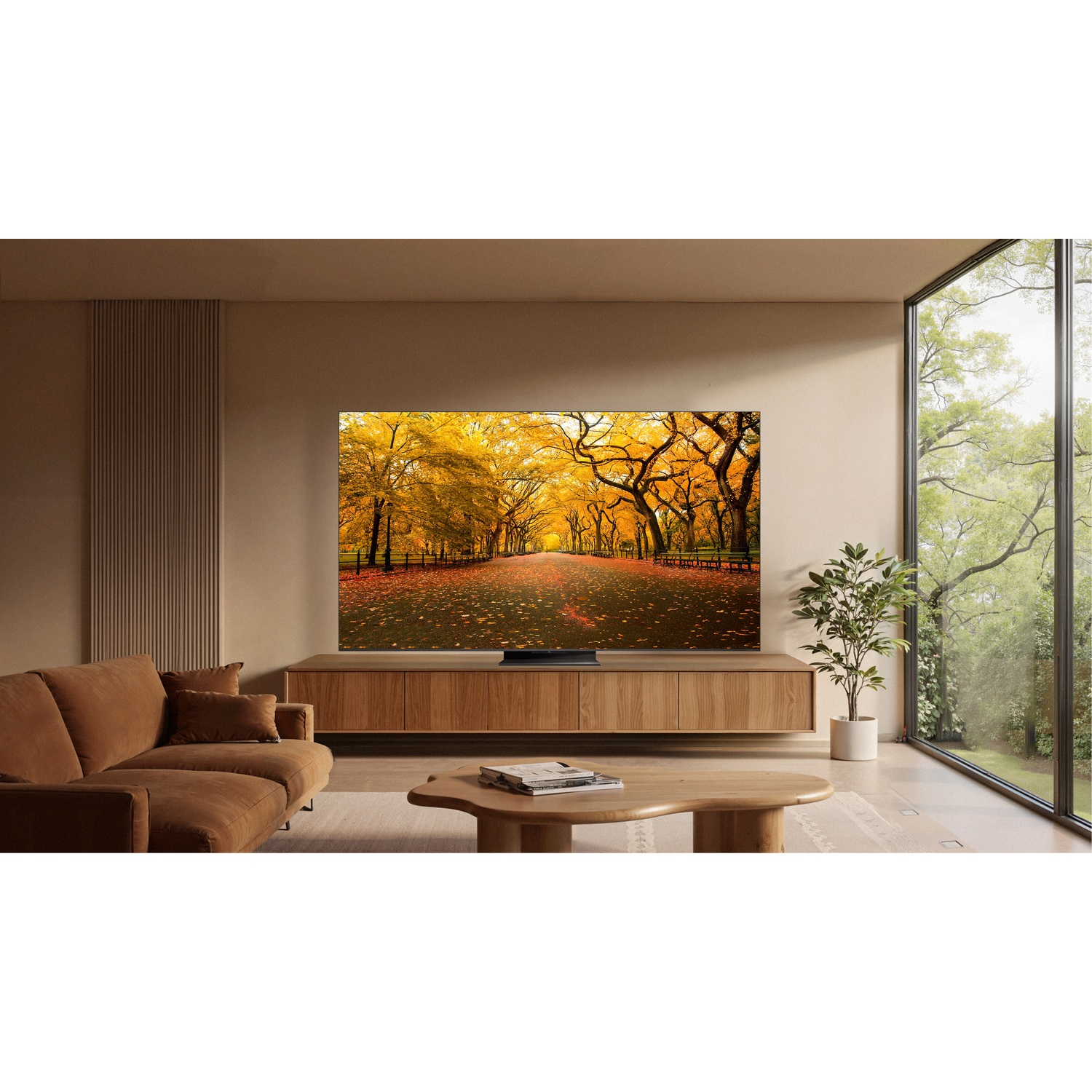 Soggiorno con divano, tavolino, TV con alberi autunnali e grande finestra.