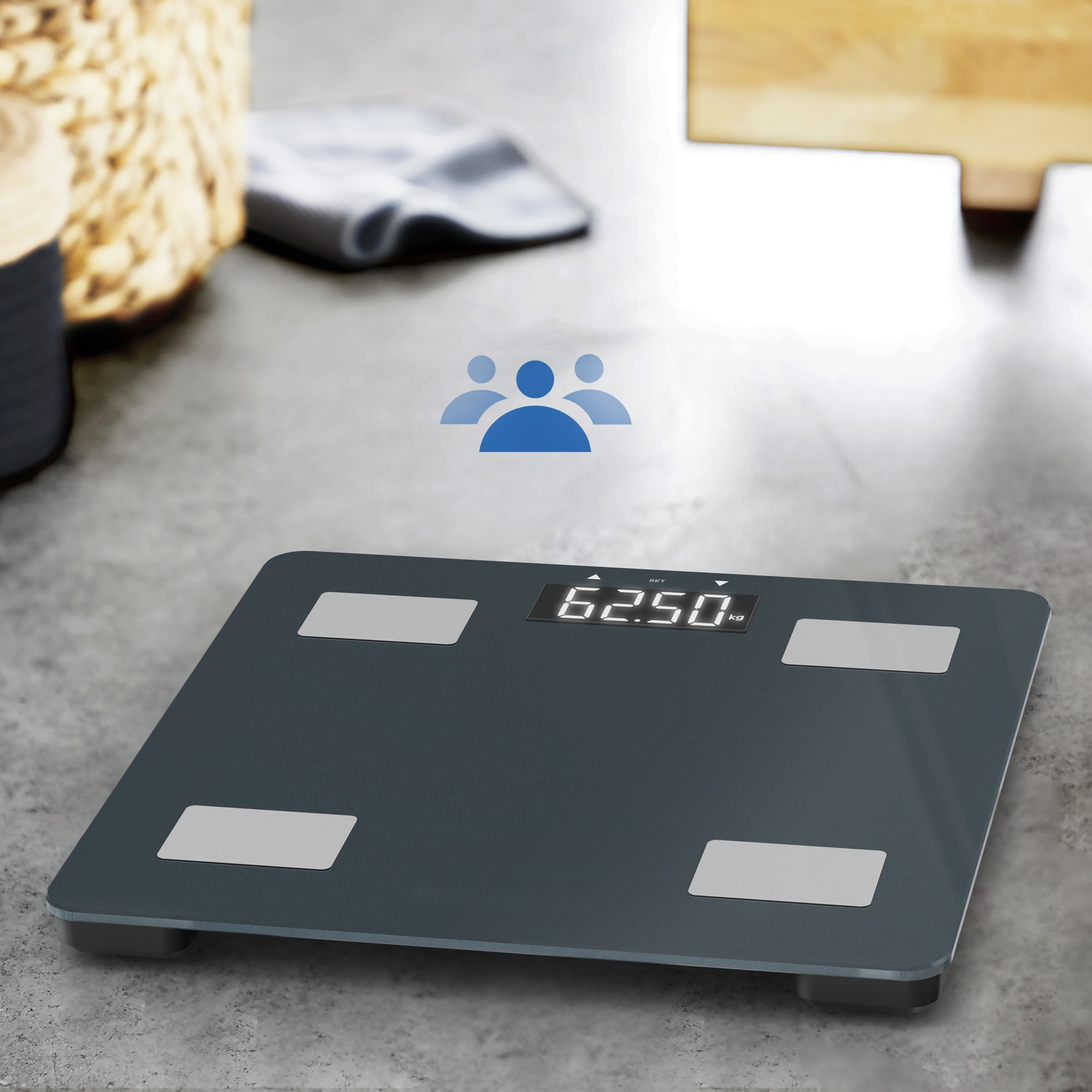Een donkergrijze digitale weegschaal toont 62,50 kg. Vier zilveren pads op schaal.