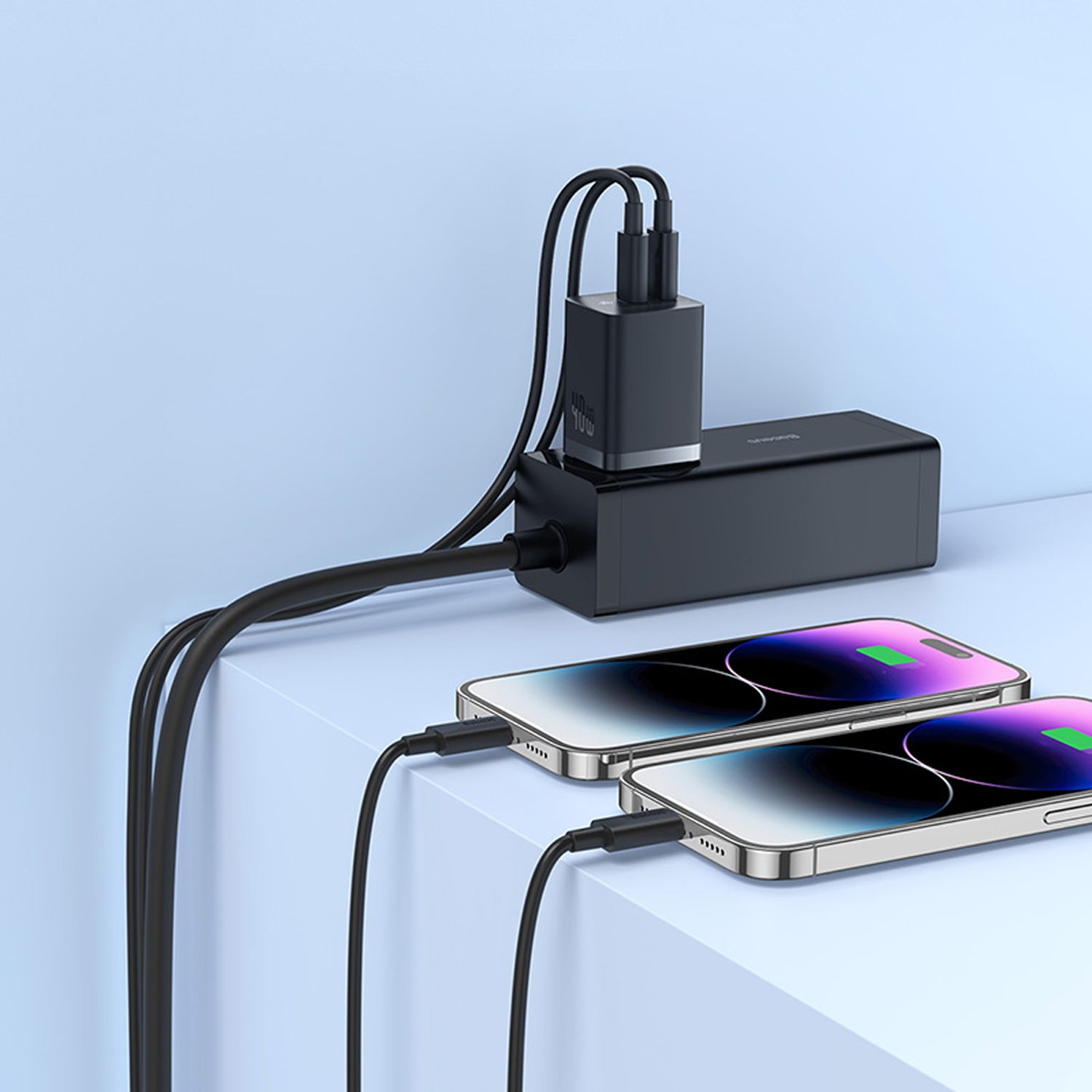 Dos smartphones se cargan a través de un cargador negro con cables.