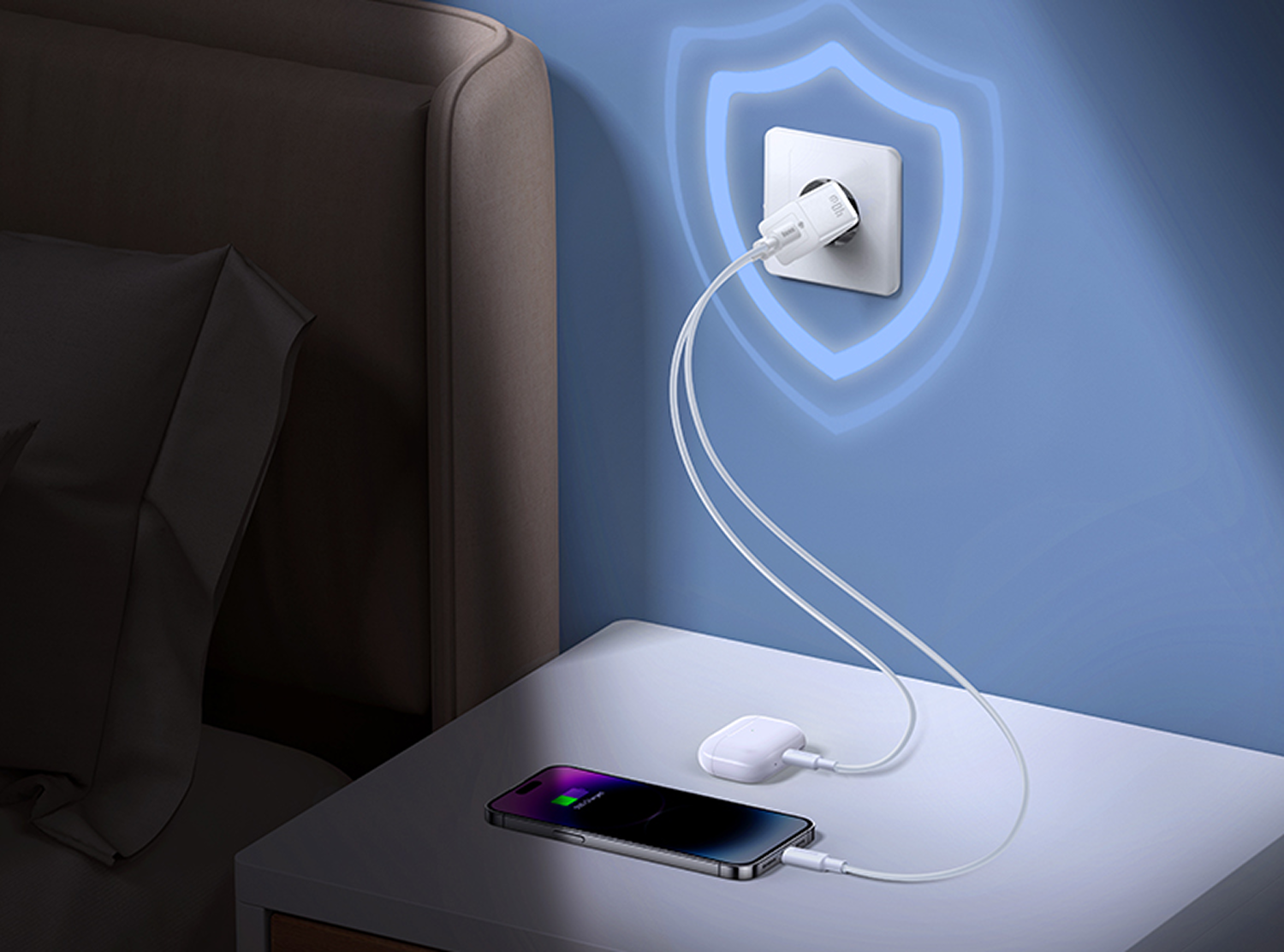 Un teléfono y un estuche de auriculares se cargan en una mesita de noche junto a una cama. Un cargador está enchufado a la pared.