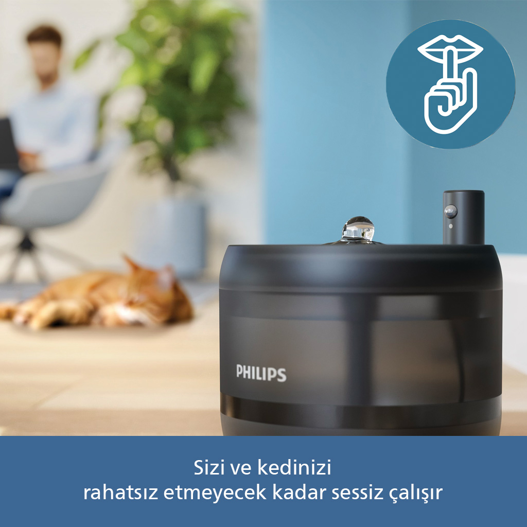 Arka planda uyuyan bir kedi ile sessiz bir Philips nemlendirici.