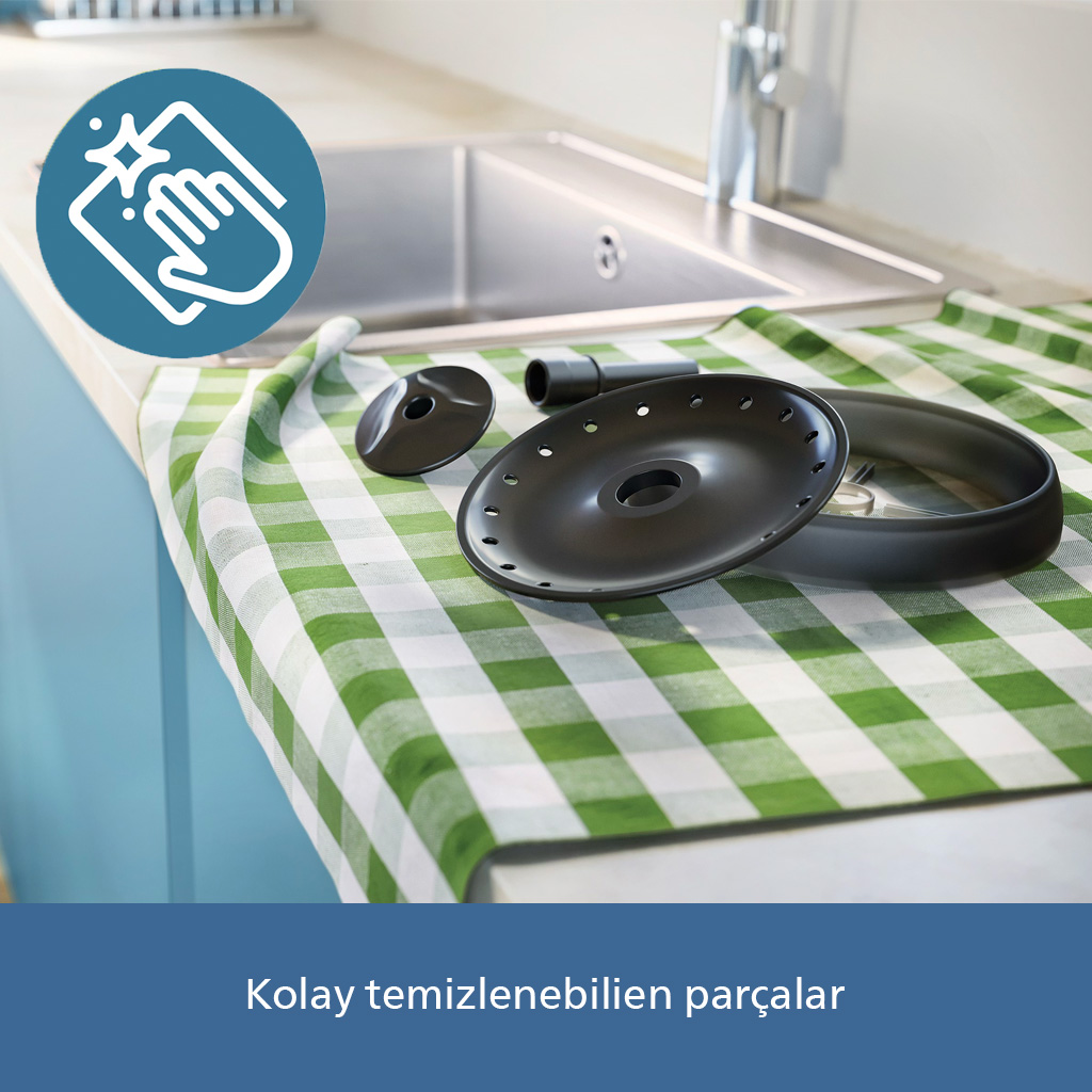 Siyah parçalar lavabonun yanında yeşil-beyaz kareli örtü üzerinde.