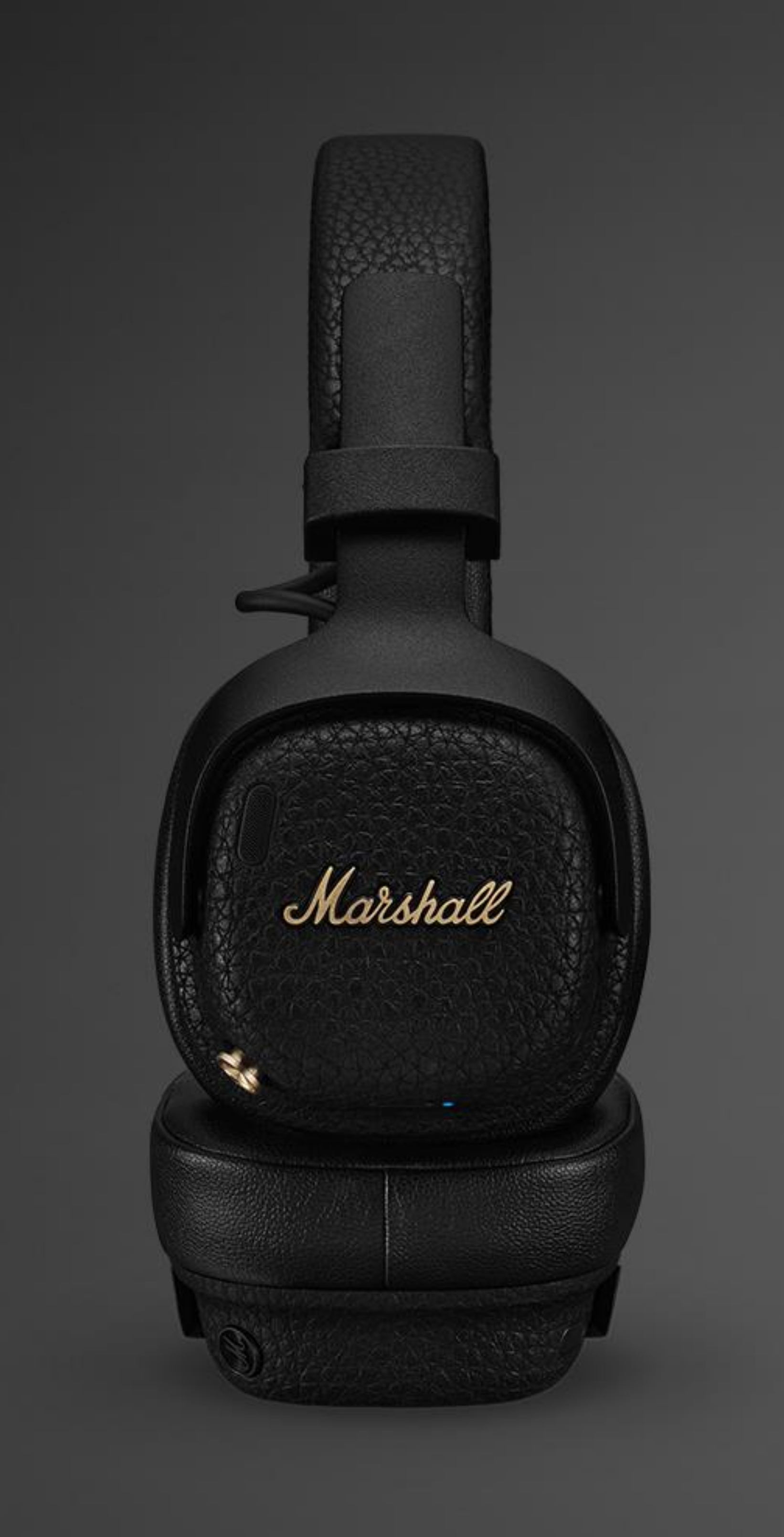 Schwarze Marshall-Kopfhörer mit goldenem Logo auf grauem Hintergrund.