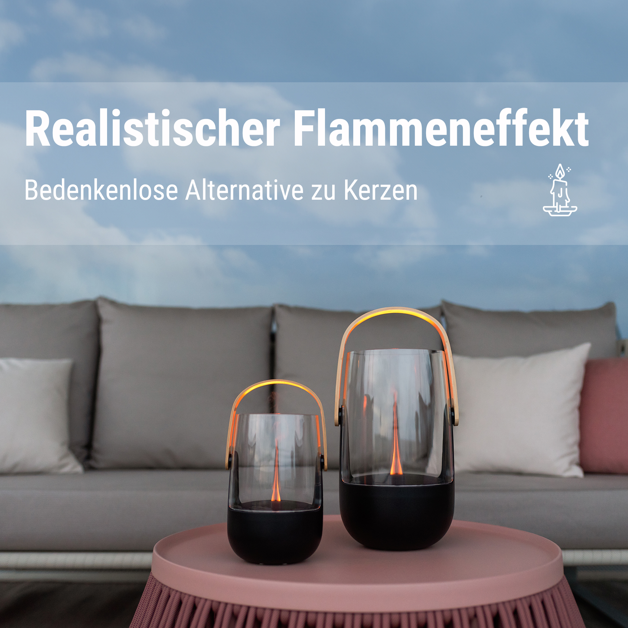 Zwei Laternen mit Flammen-Effekt auf einem rosa Tisch vor einem Sofa.