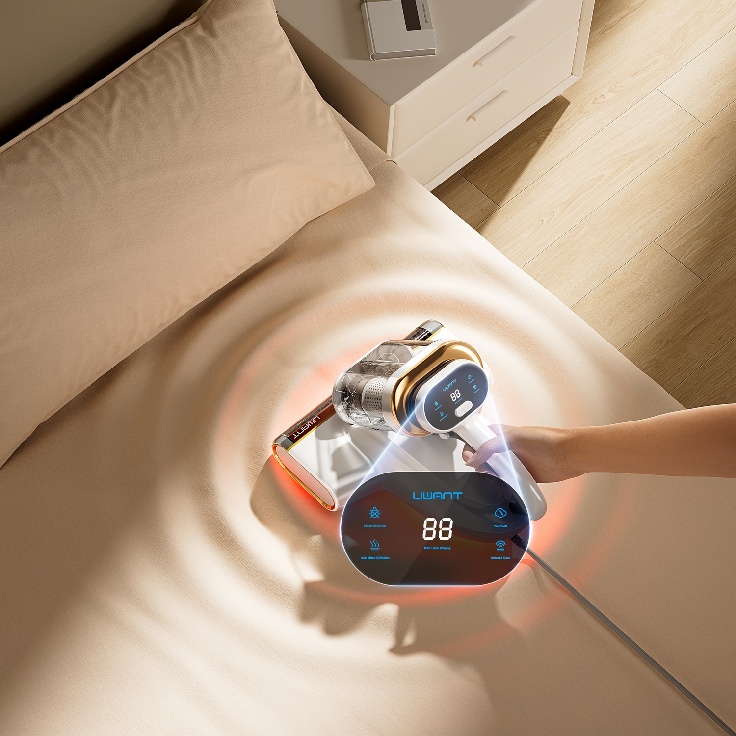 A handheld vacuum with a display cleans a light brown bed. Red waves indicate suction power.