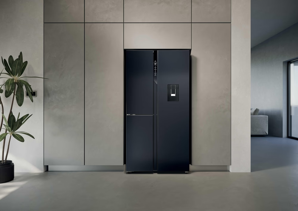 Ein moderner schwarzer Side-by-Side-Kühlschrank mit Wasserspender in einer minimalistischen Küche.
