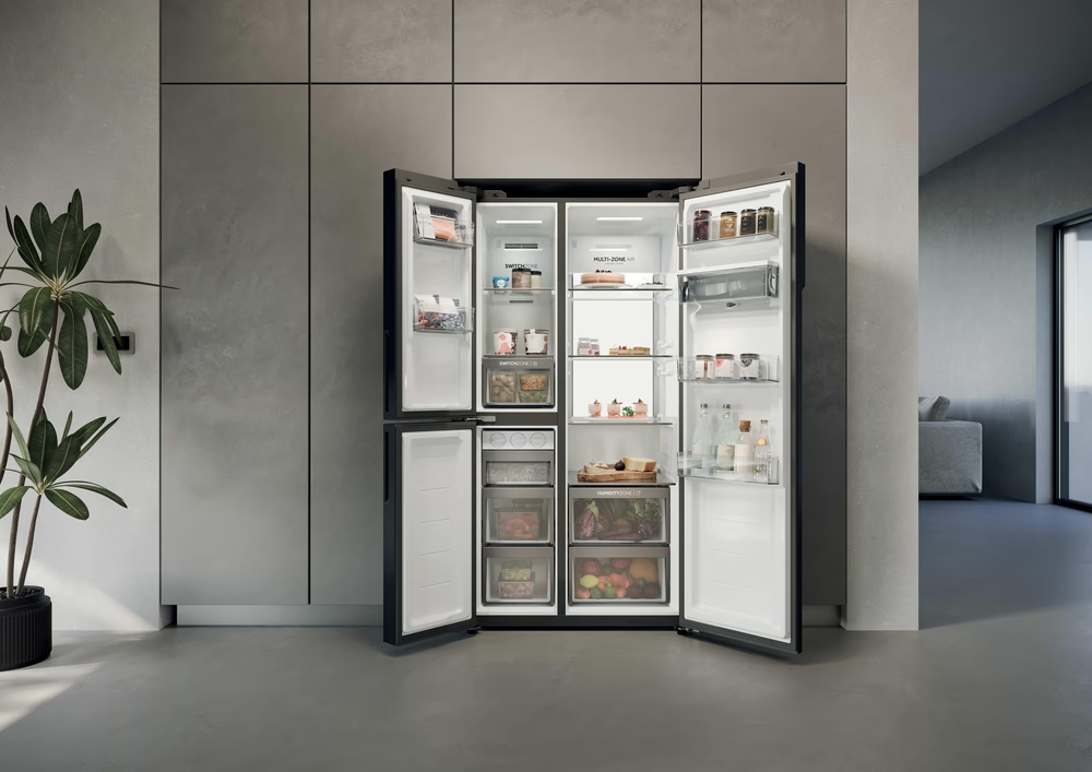 Ein moderner schwarzer Kühlschrank mit offenen Türen, gefüllt mit Lebensmitteln.