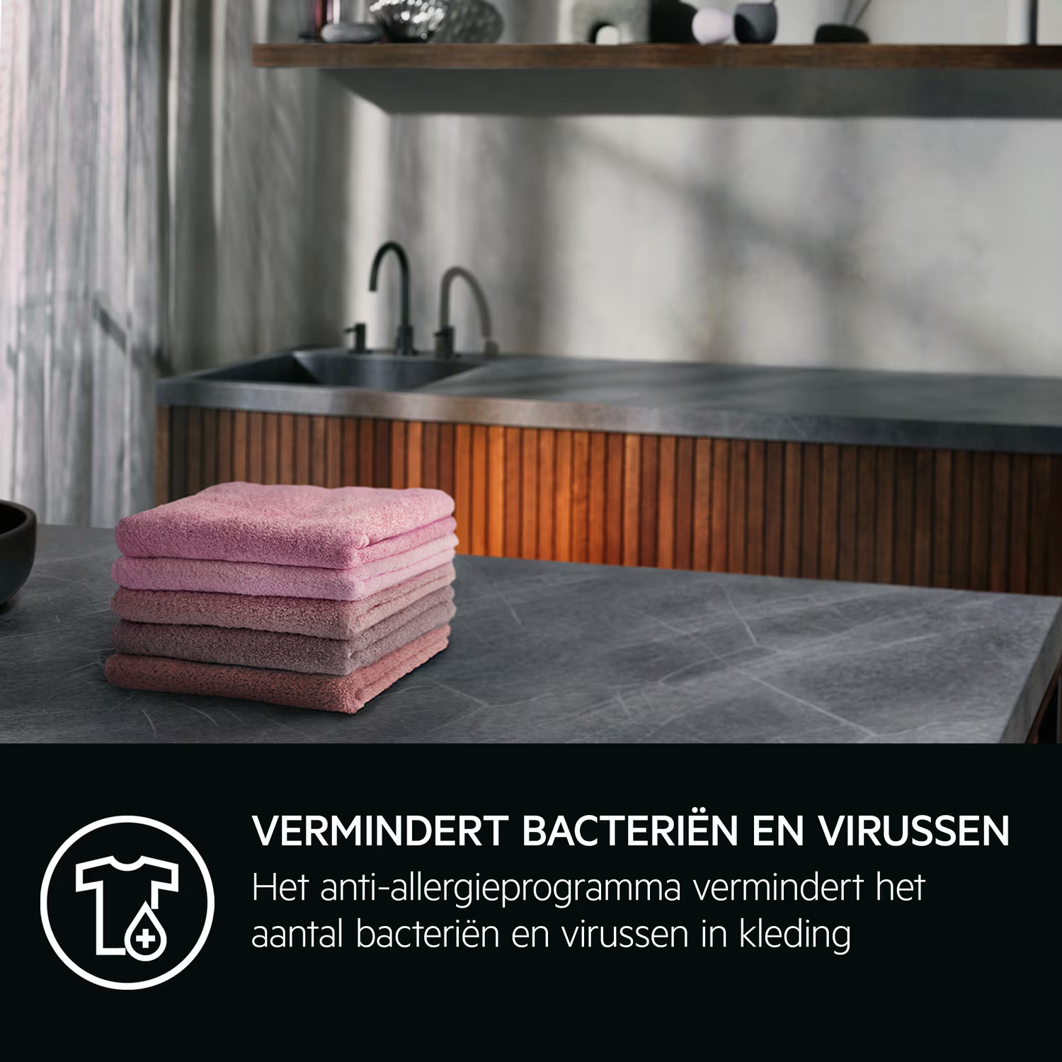 Gestapelde roze handdoeken op een tafel voor een wastafel.