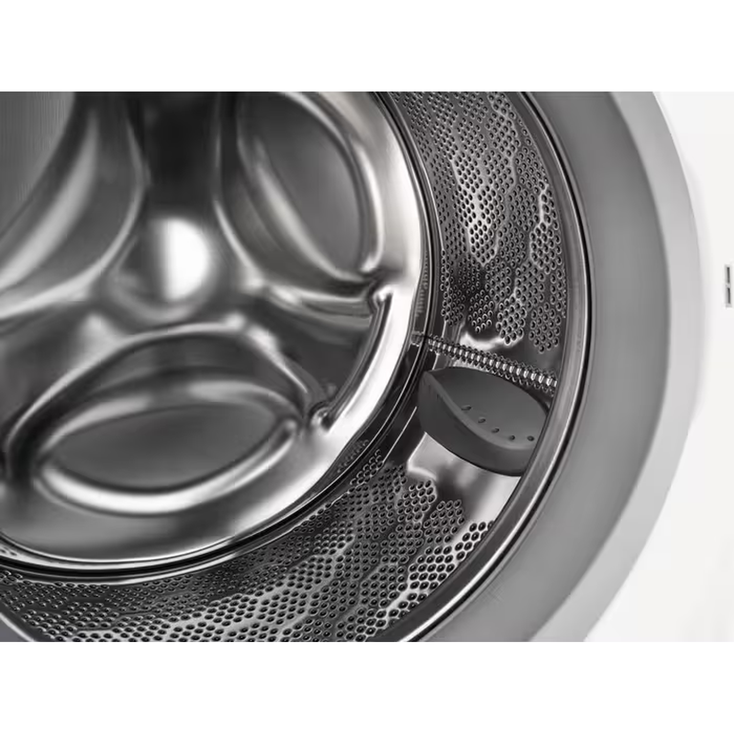 Binnenaanzicht van de trommel van een wasmachine met metalen oppervlak en kleine gaatjes.