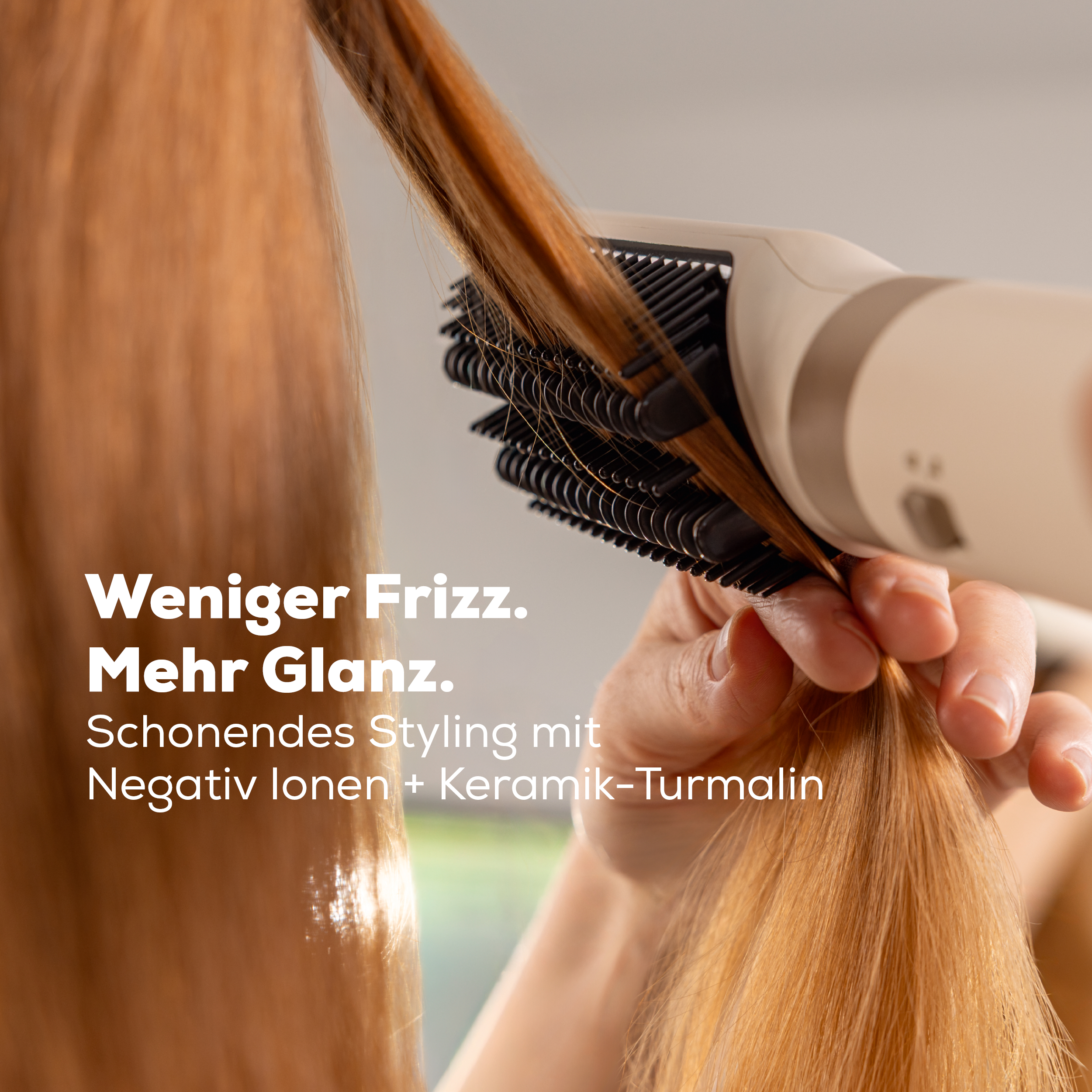 Eine Hand benutzt einen Haarstyler mit rotierenden Bürsten auf glänzendem Haar.