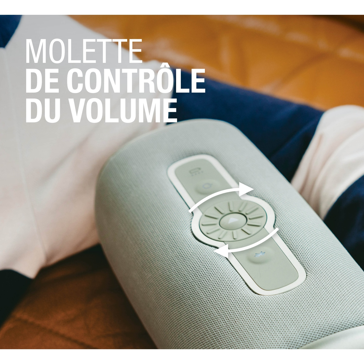 Un haut-parleur gris avec molette de volume et flèches indiquant la rotation.