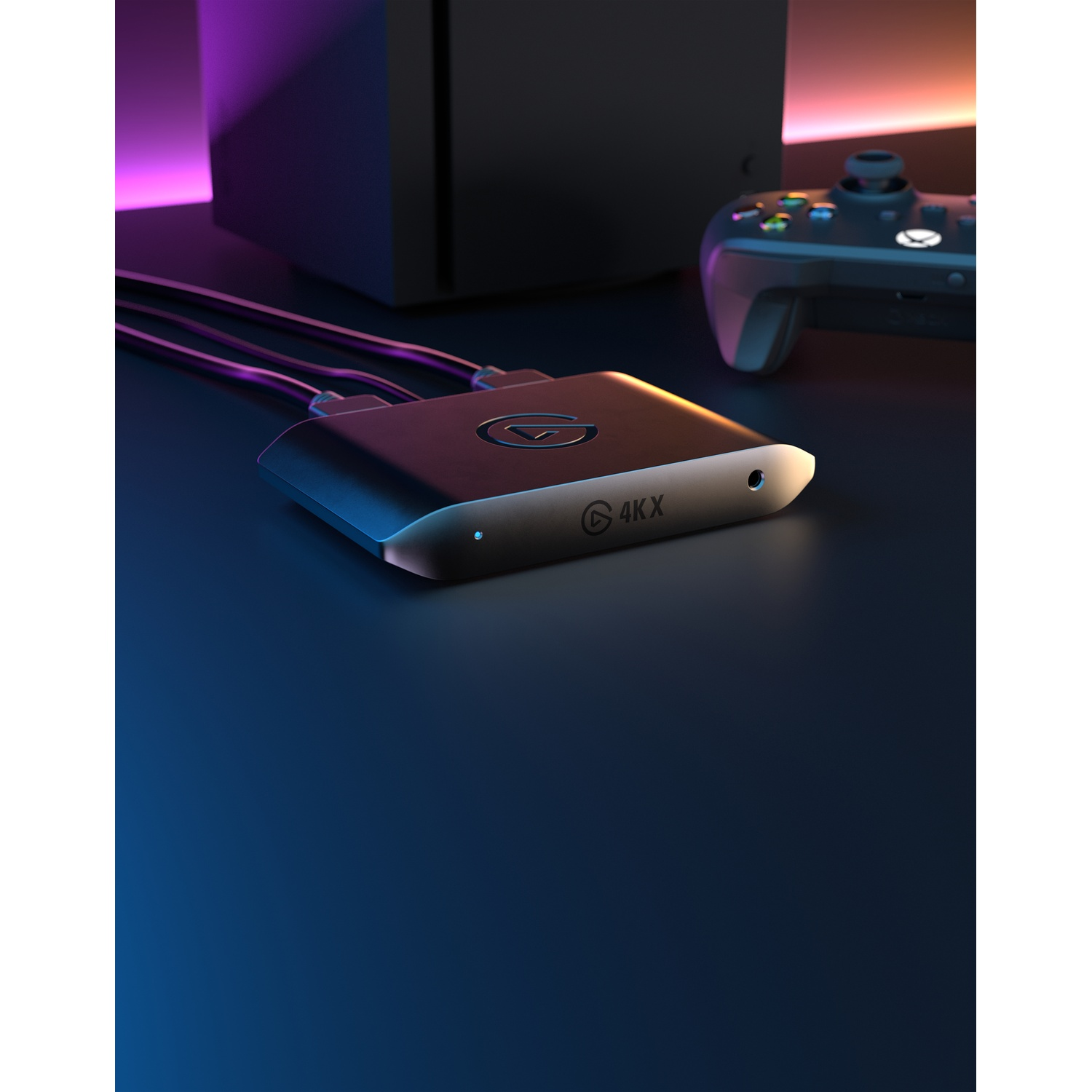 Un appareil de capture de jeu noir avec des câbles, une manette et une console.